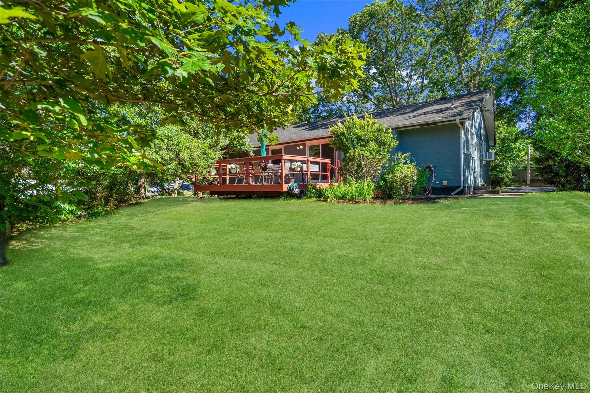 Expansive lawn area with mature trees and a multi-level wood deck Expansive lawn area with mature trees and a multi-level wood deck