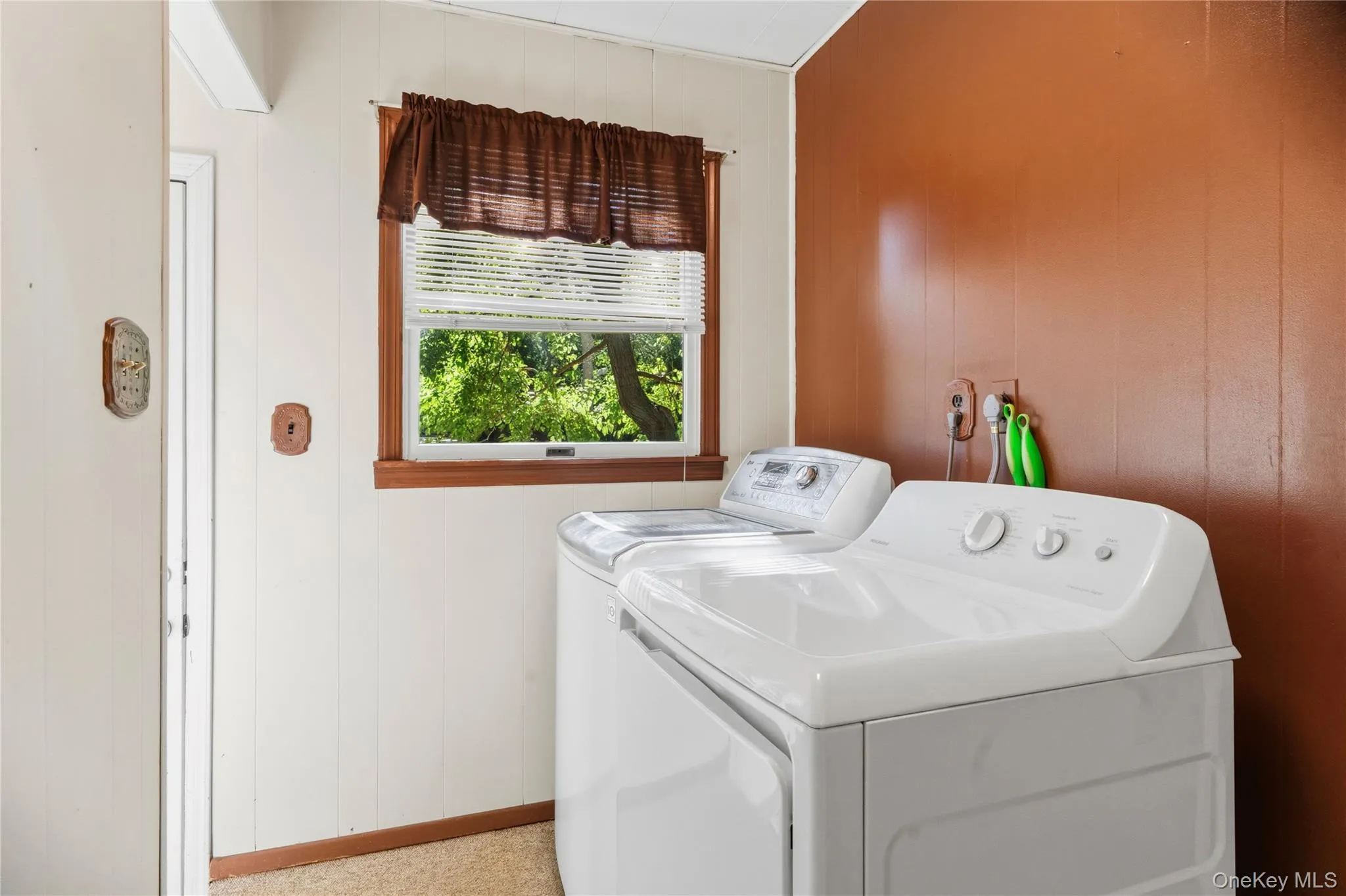 Laundry area with light-colored vertical paneling and a contrasting warm-toned accent wall Laundry area with light-colored vertical paneling and a contrasting warm-toned accent wall