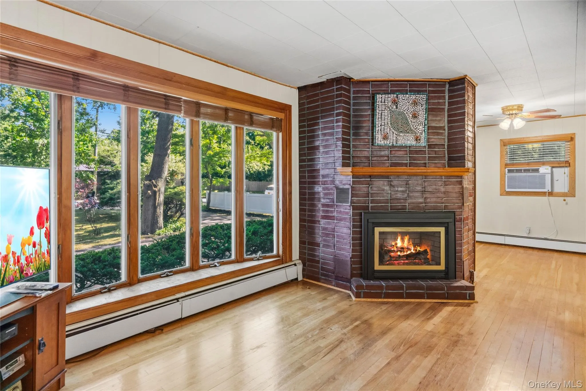 Bay window featuring wood-finish framing with midcentury modern style fireplace Bay window featuring wood-finish framing with midcentury modern style fireplace