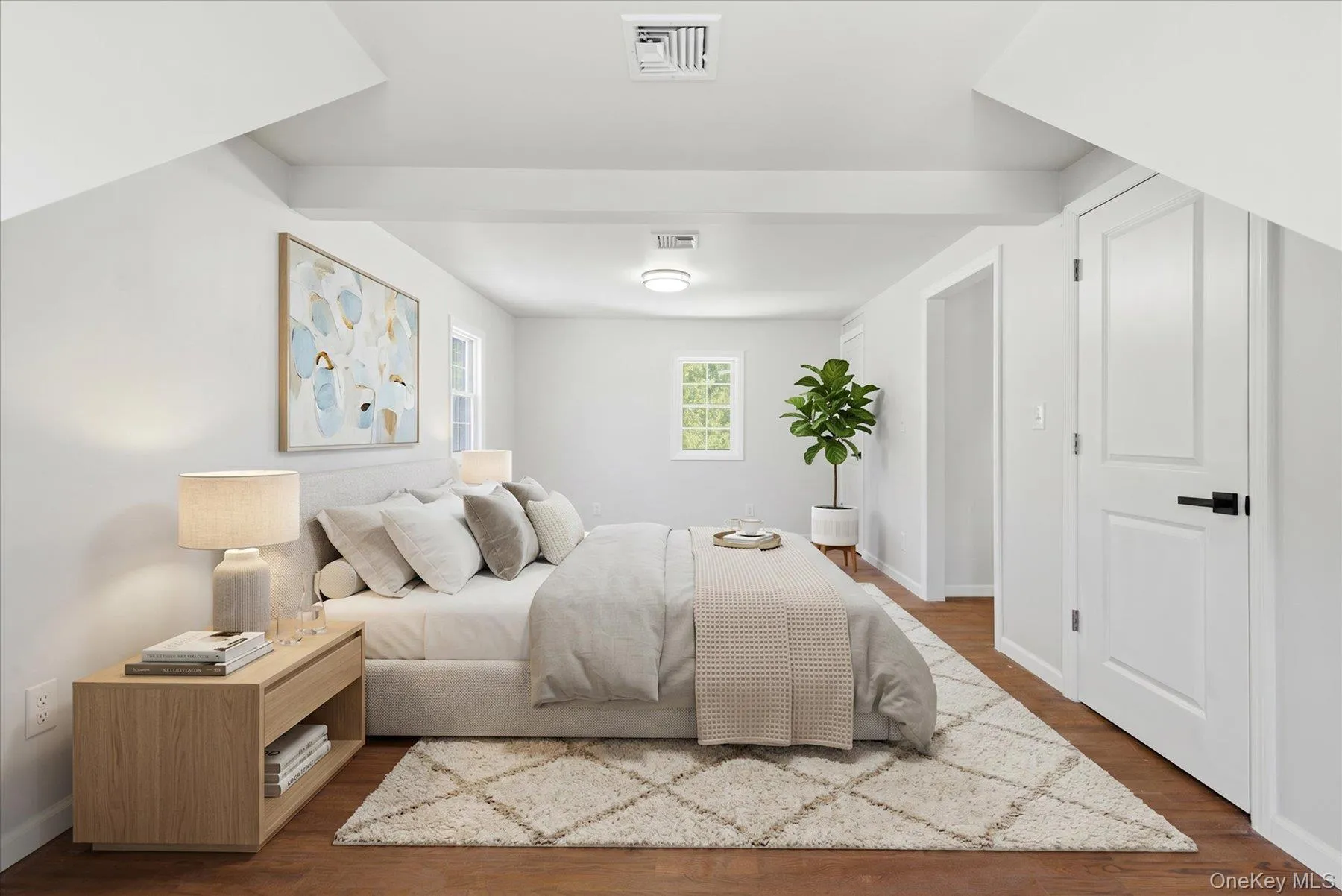 Spacious room featuring wood-finish flooring, white walls, and bright white trim Spacious room featuring wood-finish flooring, white walls, and bright white trim