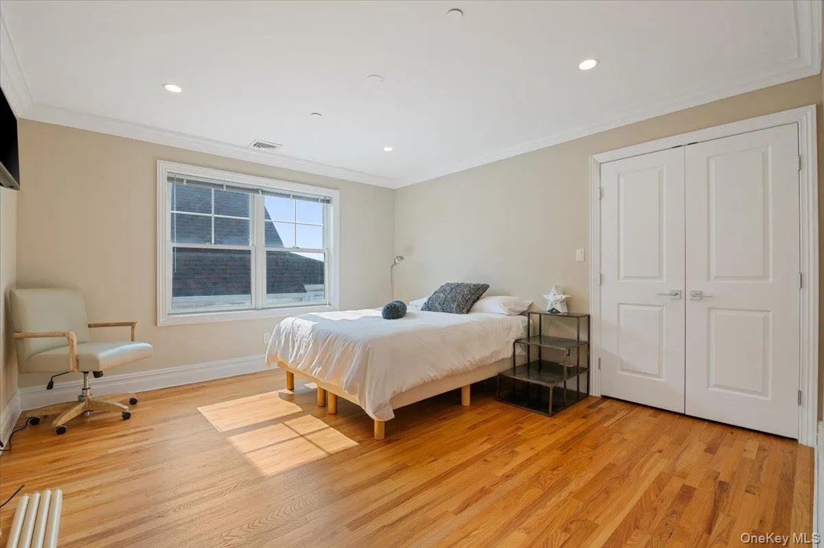 Bedroom with light wood finished floors, crown molding, recessed lighting, and a closet Bedroom with light wood finished floors, crown molding, recessed lighting, and a closet