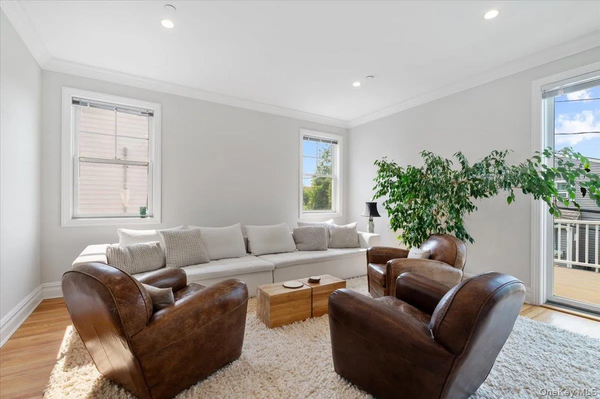 Living room with light wood-style flooring, crown molding, and recessed lighting Living room with light wood-style flooring, crown molding, and recessed lighting