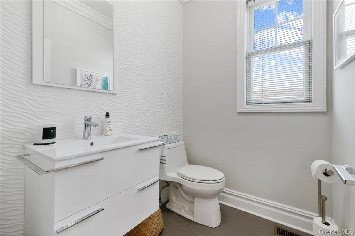 Half bathroom featuring tile patterned floors, vanity, and crown molding Half bathroom featuring tile patterned floors, vanity, and crown molding