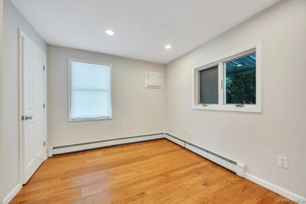 Hardwood flooring throughout this bright room featuring recessed lighting Hardwood flooring throughout this bright room featuring recessed lighting