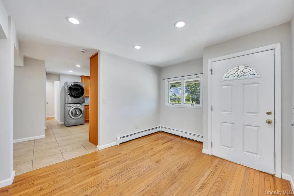 Entryway featuring a white paneled door with an arched decorative glass insert, wood-finish flooring, and recessed lighting Entryway featuring a white paneled door with an arched decorative glass insert, wood-finish flooring, and recessed lighting