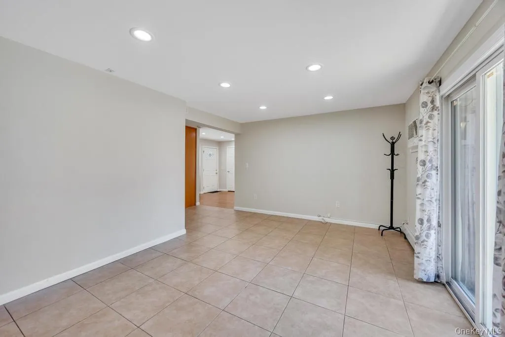 Spacious interior featuring neutral wall tones, recessed lighting, and tile flooring Spacious interior featuring neutral wall tones, recessed lighting, and tile flooring