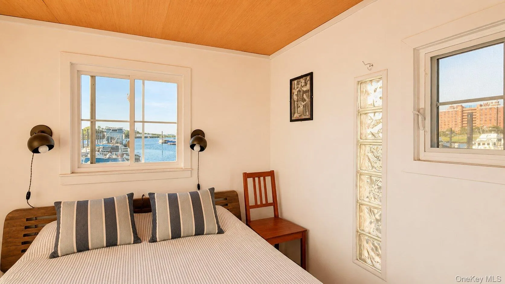 Room featuring large grid-pane windows, a wood-finish ceiling, and white walls Room featuring large grid-pane windows, a wood-finish ceiling, and white walls