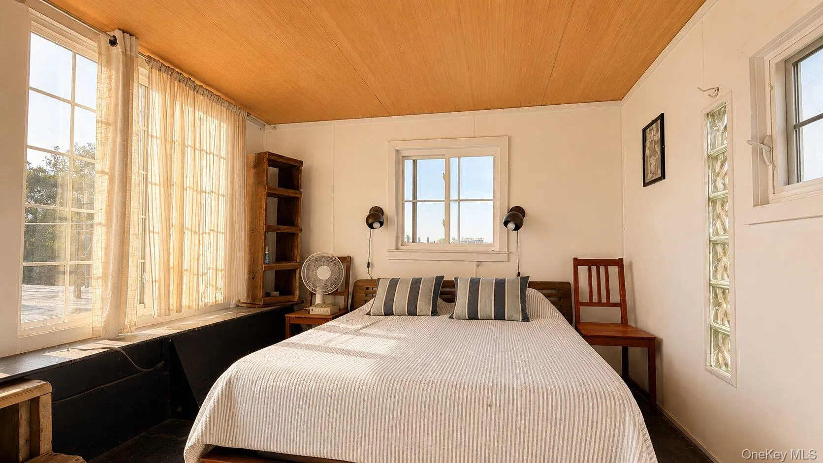 Room featuring large grid-pane windows, a wood-finish ceiling, and white walls Room featuring large grid-pane windows, a wood-finish ceiling, and white walls