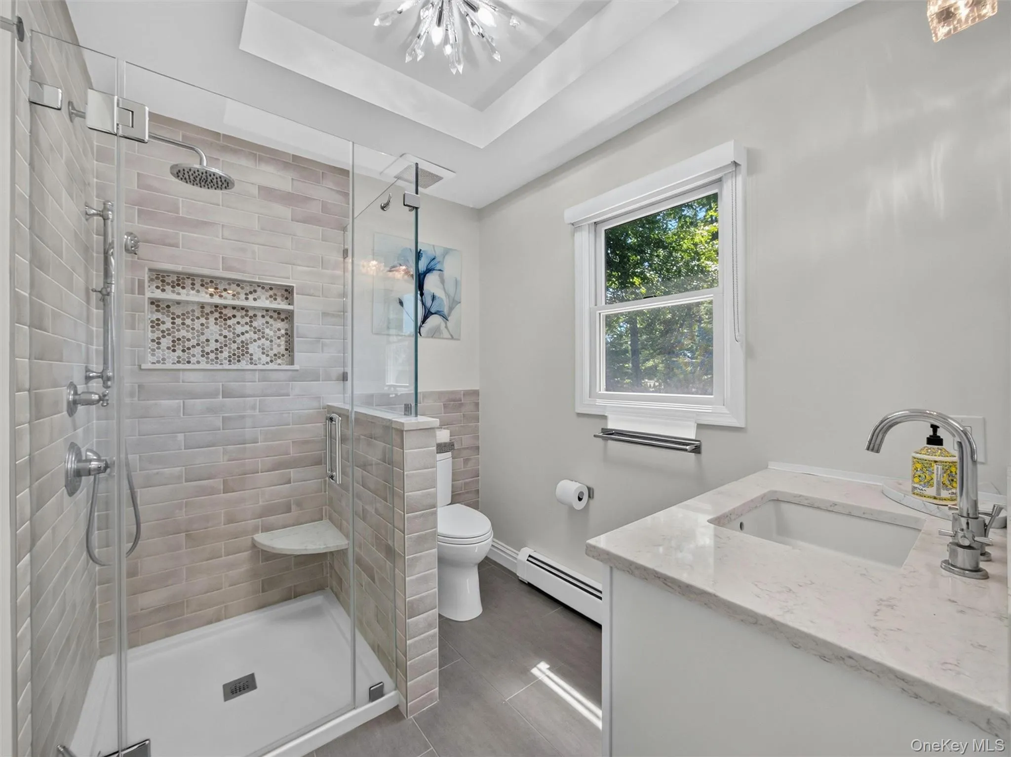 Bright and beautifully updated, the primary bath features a convenient walk-in shower. Bright and beautifully updated, the primary bath features a convenient walk-in shower.