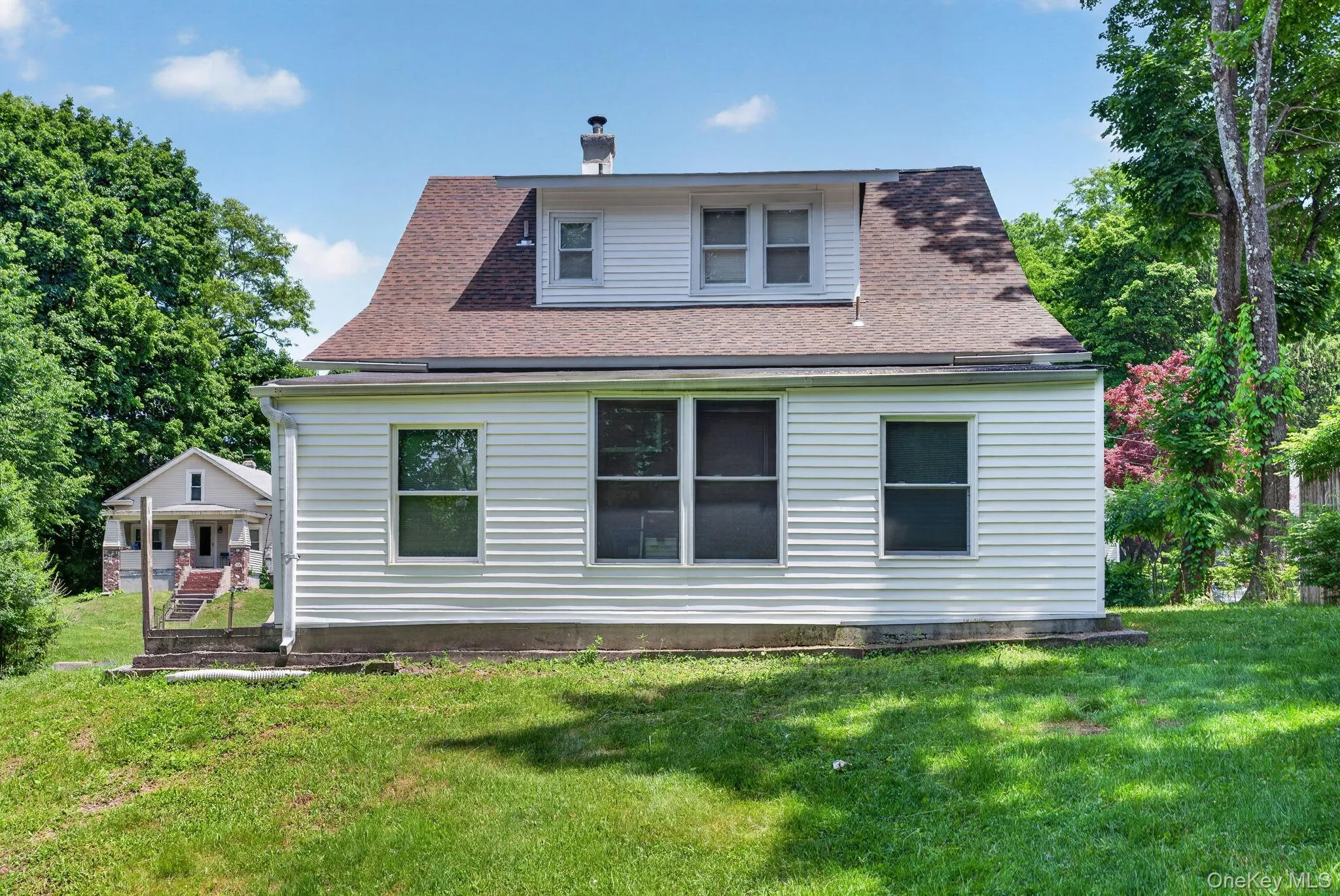The rear exterior of this charming Cape Cod home is both inviting and functional, offering a wonderful extension of the living space. The classic architectural design is complemented by attractive siding, mature landscaping, and a spacious backyard perfect for outdoor enjoyment. The rear exterior of this charming Cape Cod home is both inviting and functional, offering a wonderful extension of the living space. The classic architectural design is complemented by attractive siding, mature landscaping, and a spacious backyard perfect for outdoor enjoyment.