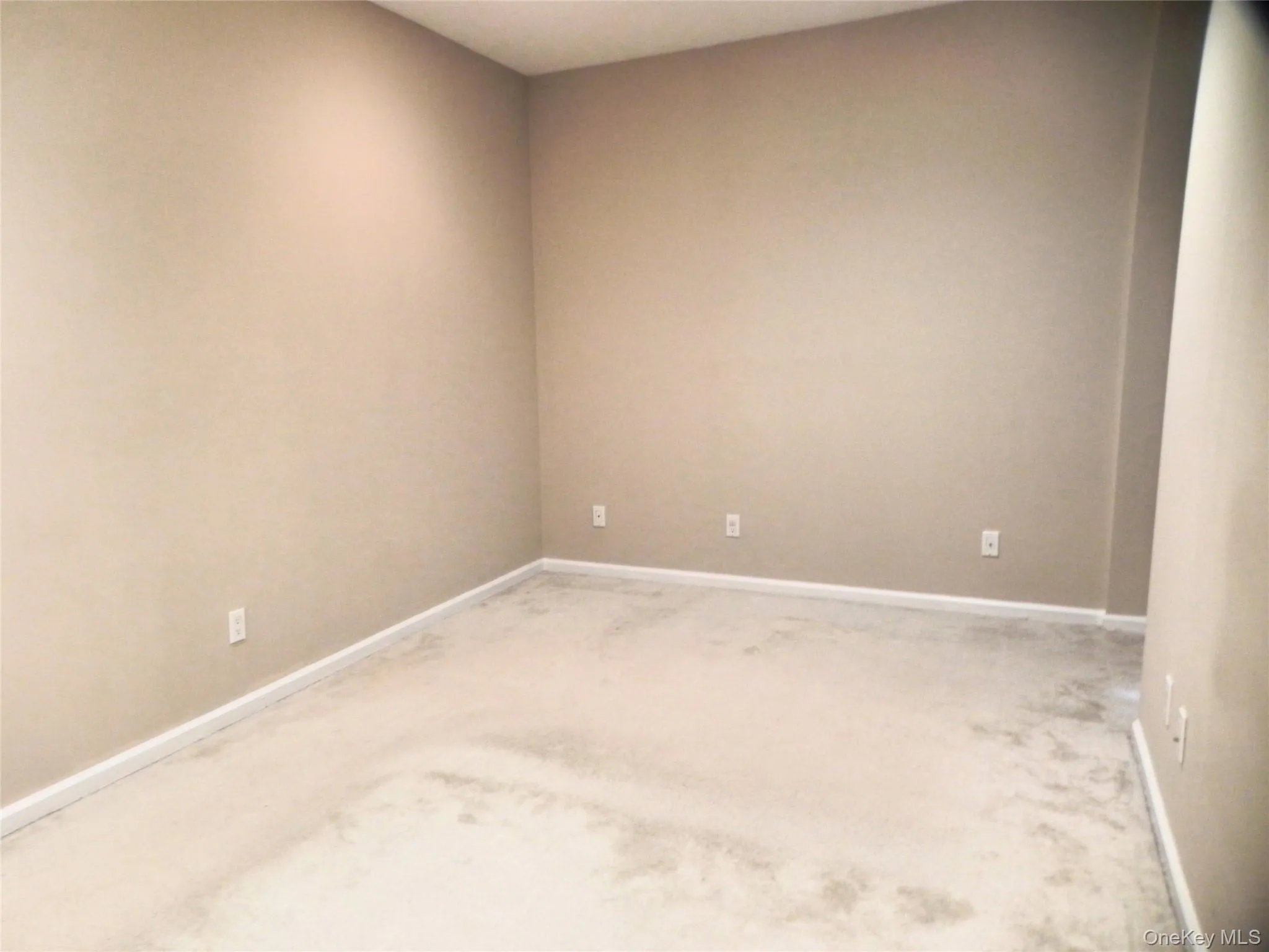 Carpeted spare room featuring baseboards Carpeted spare room featuring baseboards