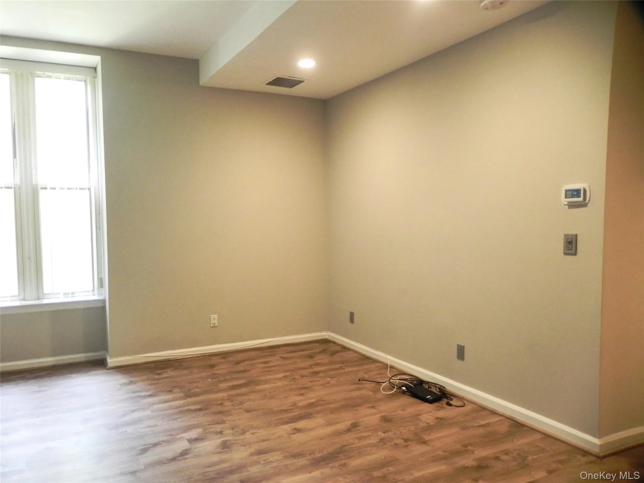 Empty room featuring healthy amount of natural light, wood finished floors, and recessed lighting Empty room featuring healthy amount of natural light, wood finished floors, and recessed lighting