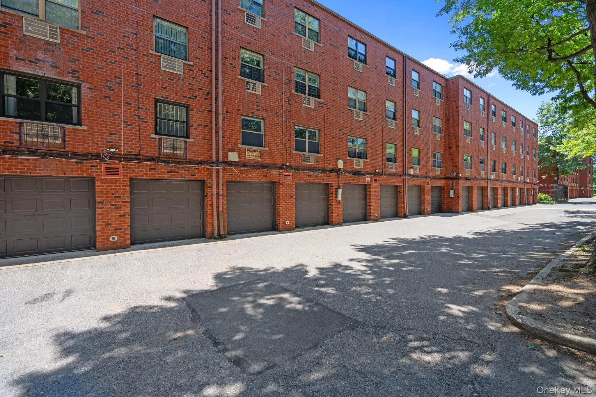 Multi-story brick building facade featuring multiple garage bays Multi-story brick building facade featuring multiple garage bays