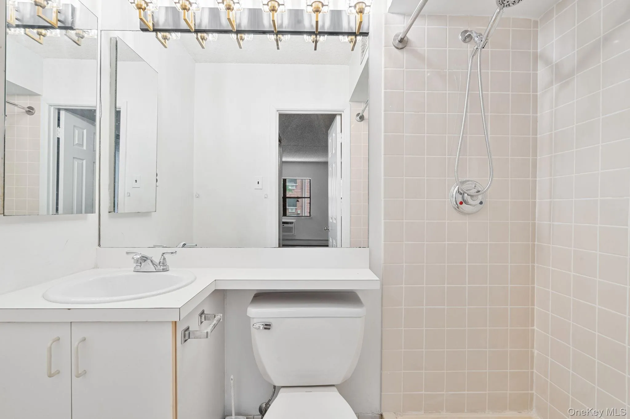 Bathroom featuring a single vanity, integrated sink, chrome faucet, and white cabinetry Bathroom featuring a single vanity, integrated sink, chrome faucet, and white cabinetry