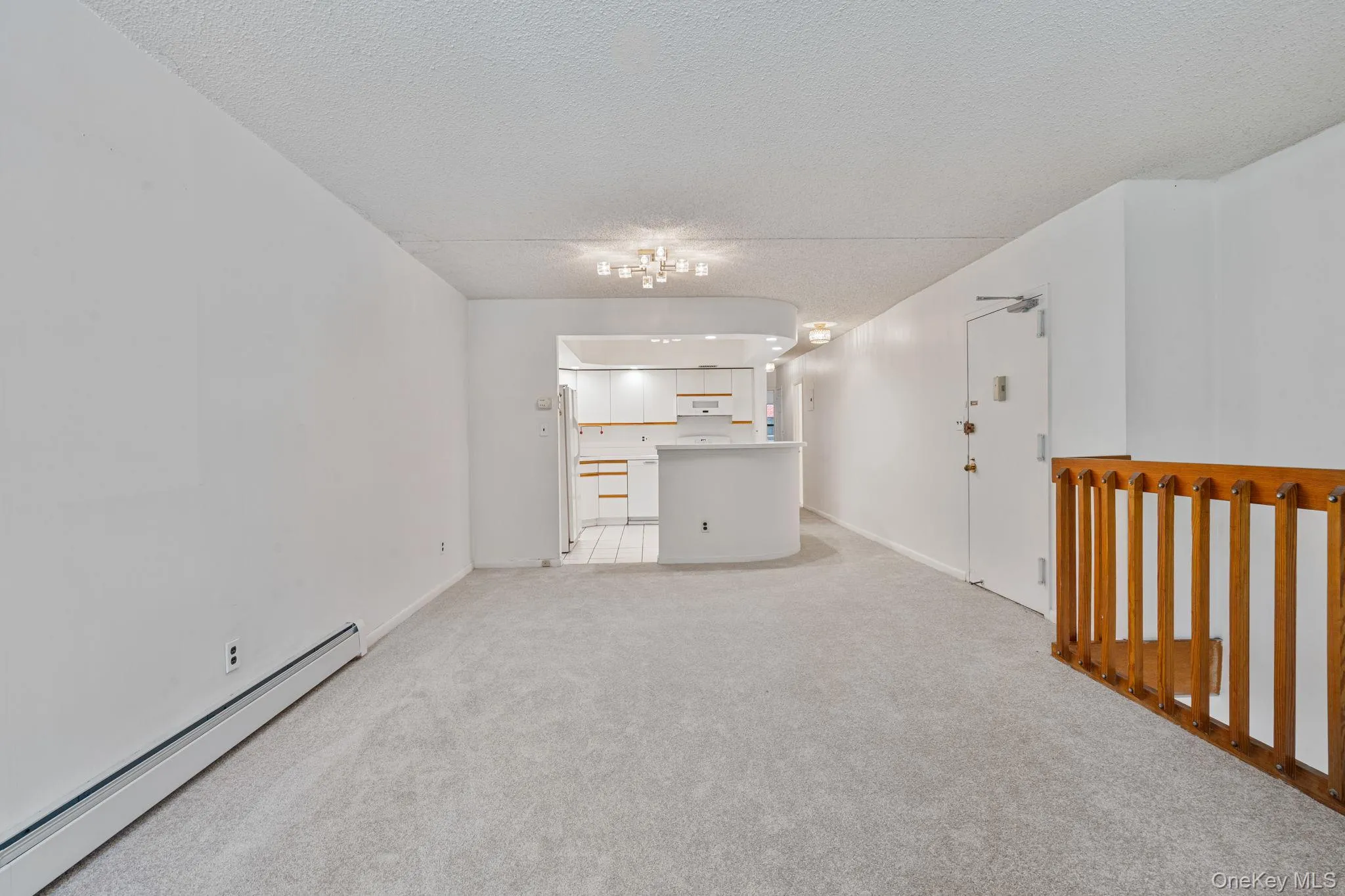 Open-concept living space featuring light gray carpeting and white walls Open-concept living space featuring light gray carpeting and white walls