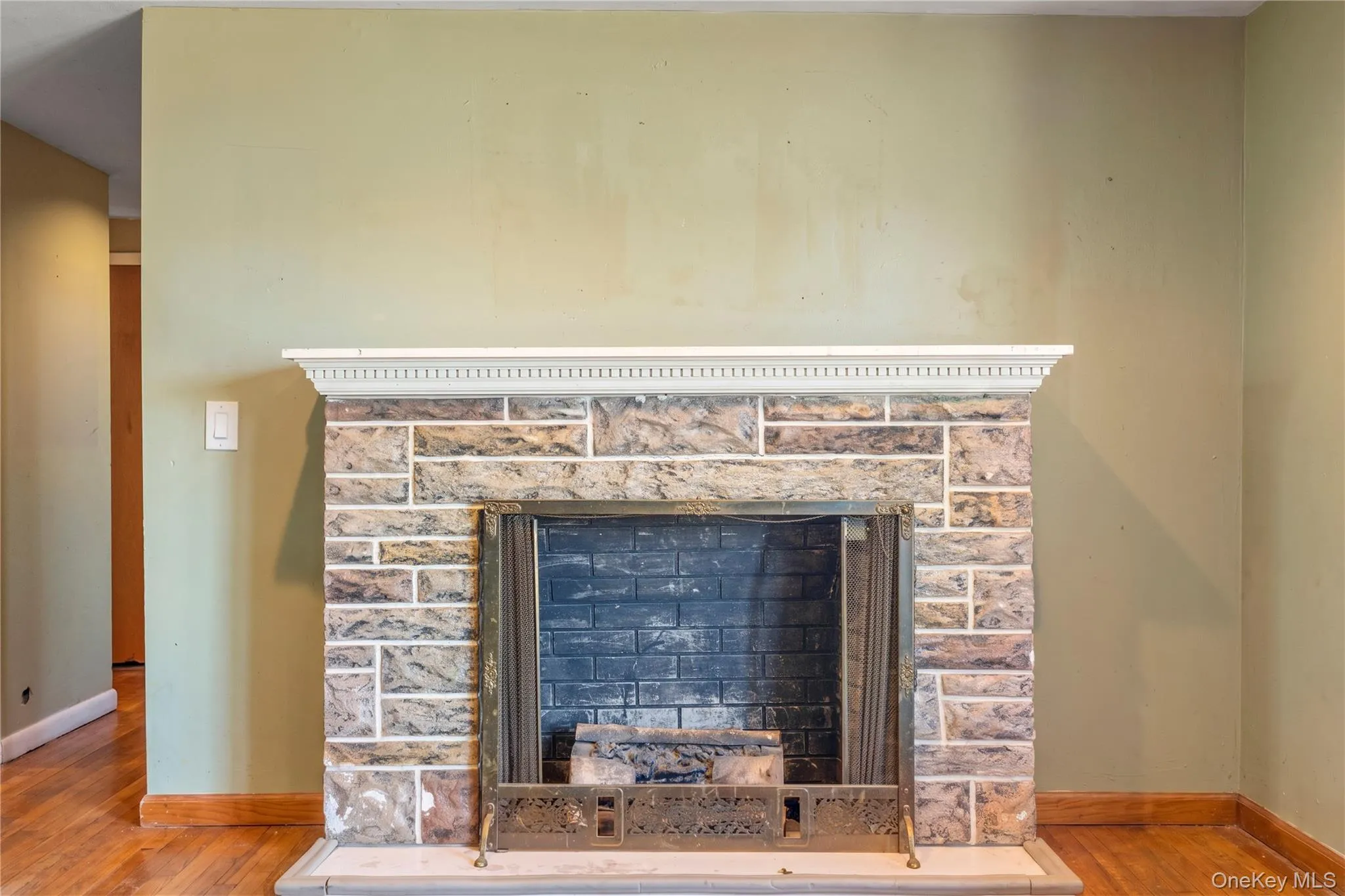 Stone-faced fireplace with a decorative mantel and hearth Stone-faced fireplace with a decorative mantel and hearth