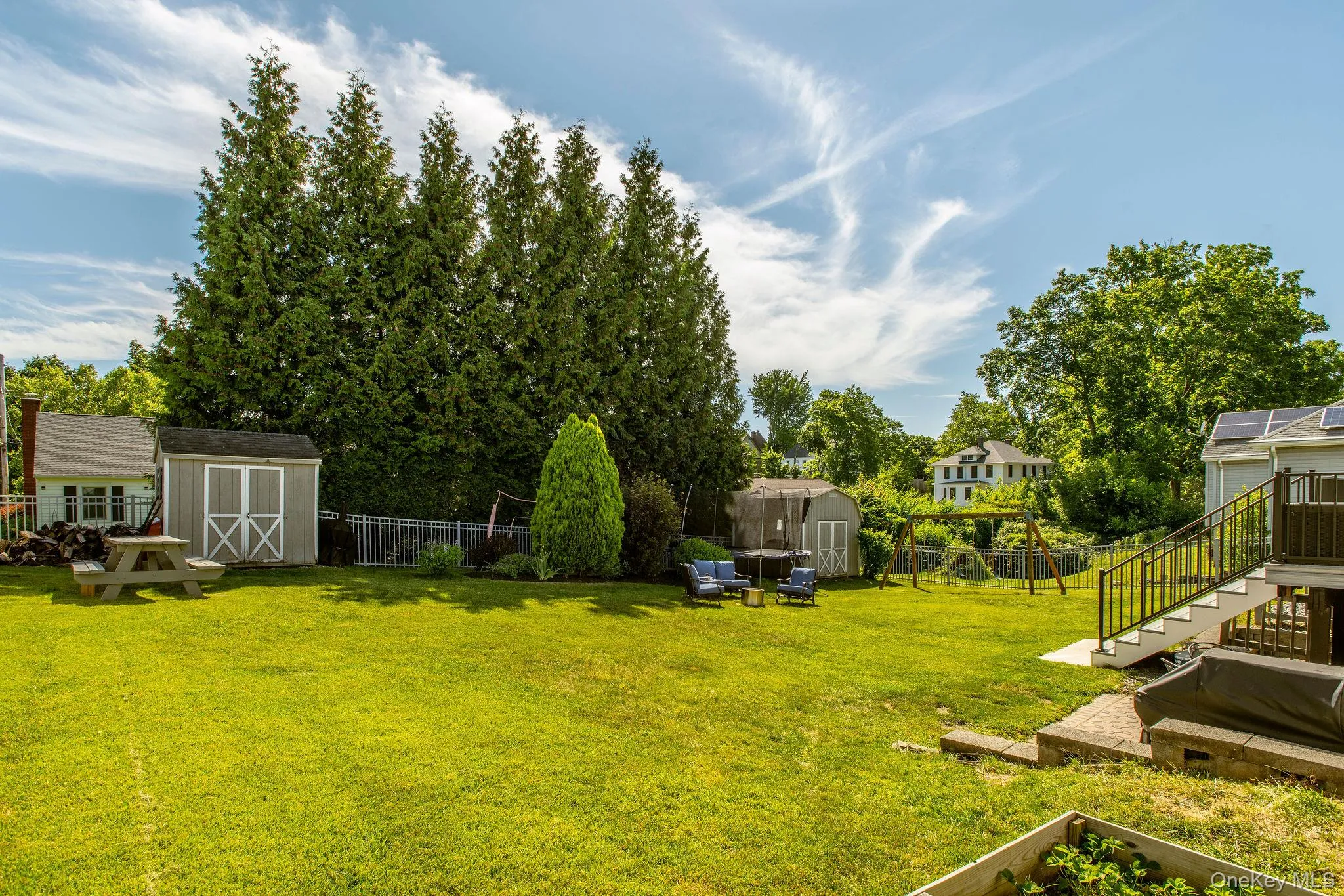 Generous backyard retreat with mature landscaping, a fire pit, storage shed, and swing set. Generous backyard retreat with mature landscaping, a fire pit, storage shed, and swing set.
