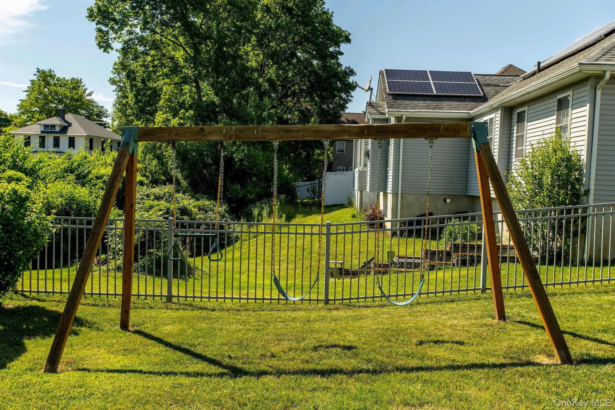 Generous backyard retreat with mature landscaping, a fire pit, storage shed, and swing set. Generous backyard retreat with mature landscaping, a fire pit, storage shed, and swing set.