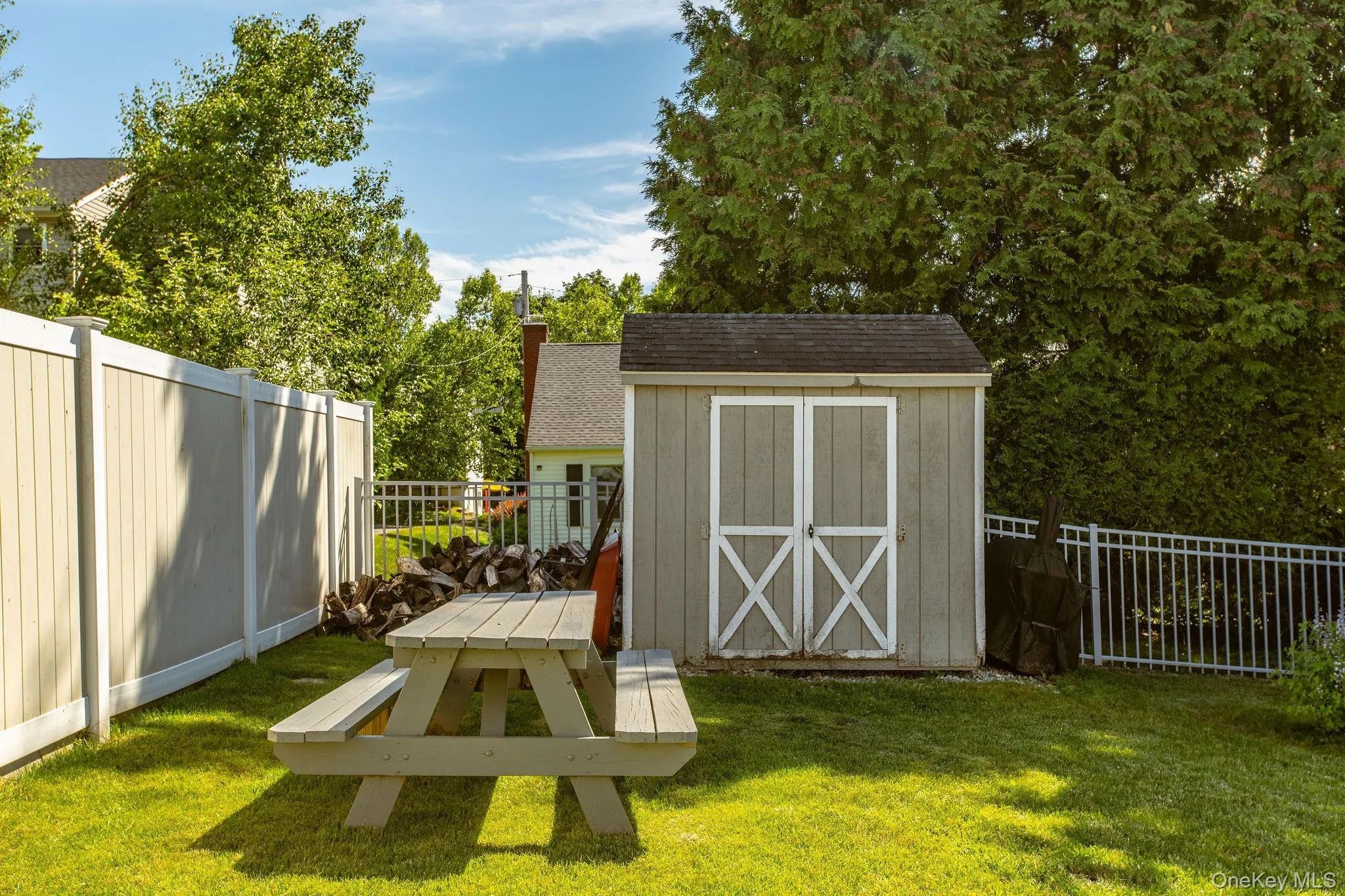 Generous backyard retreat with mature landscaping, a fire pit, storage shed, and swing set. Generous backyard retreat with mature landscaping, a fire pit, storage shed, and swing set.