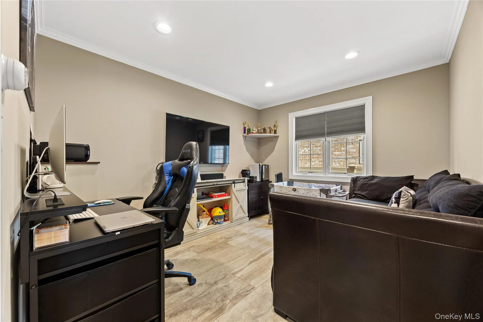 Recessed lighting illuminates this room, featuring wood-finish flooring, neutral wall tones, and crown molding Recessed lighting illuminates this room, featuring wood-finish flooring, neutral wall tones, and crown molding