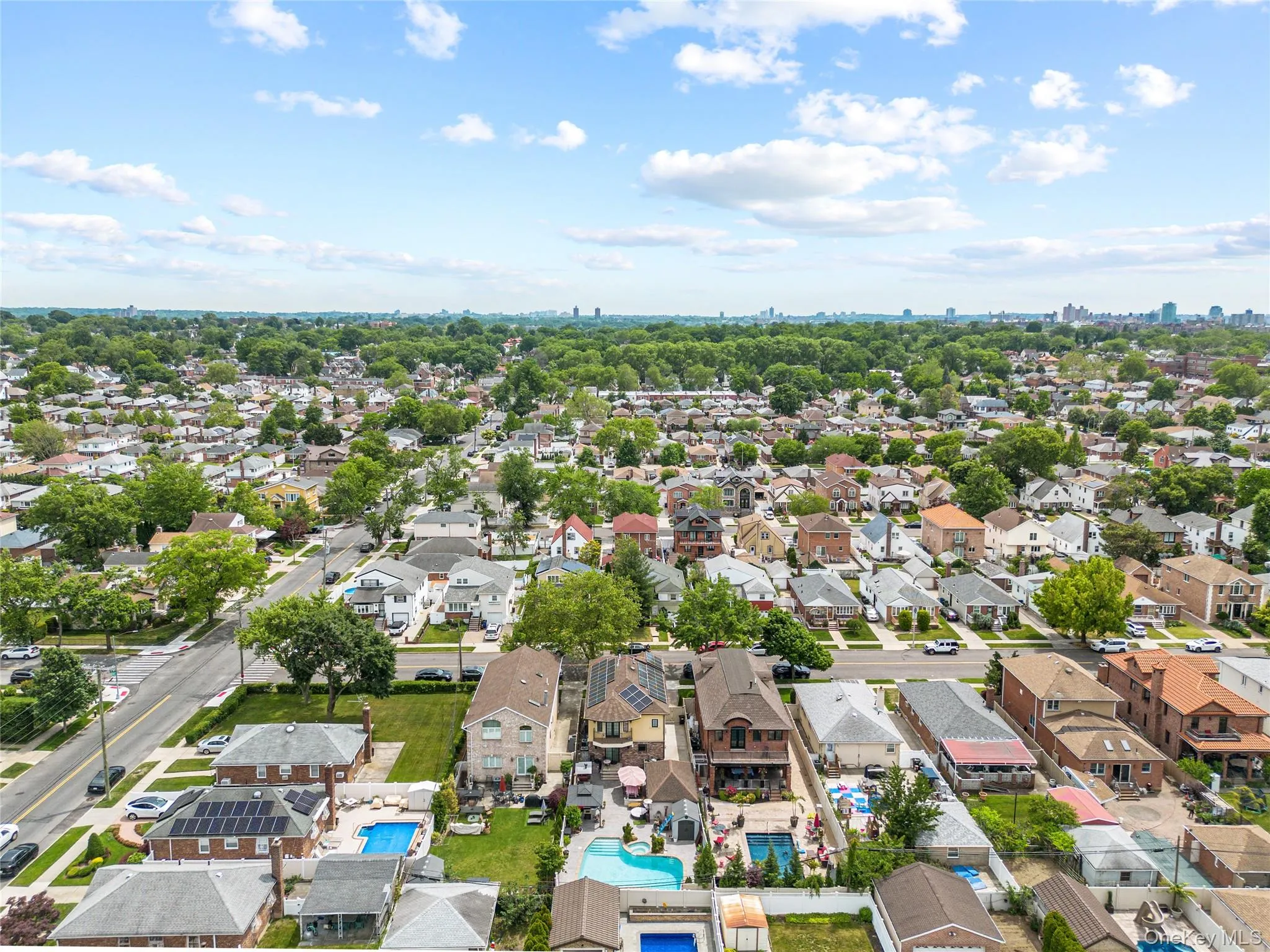 Aerial perspective showcasing a residential area with diverse architectural styles, mature tree canopies, and multiple properties featuring in-ground pools Aerial perspective showcasing a residential area with diverse architectural styles, mature tree canopies, and multiple properties featuring in-ground pools