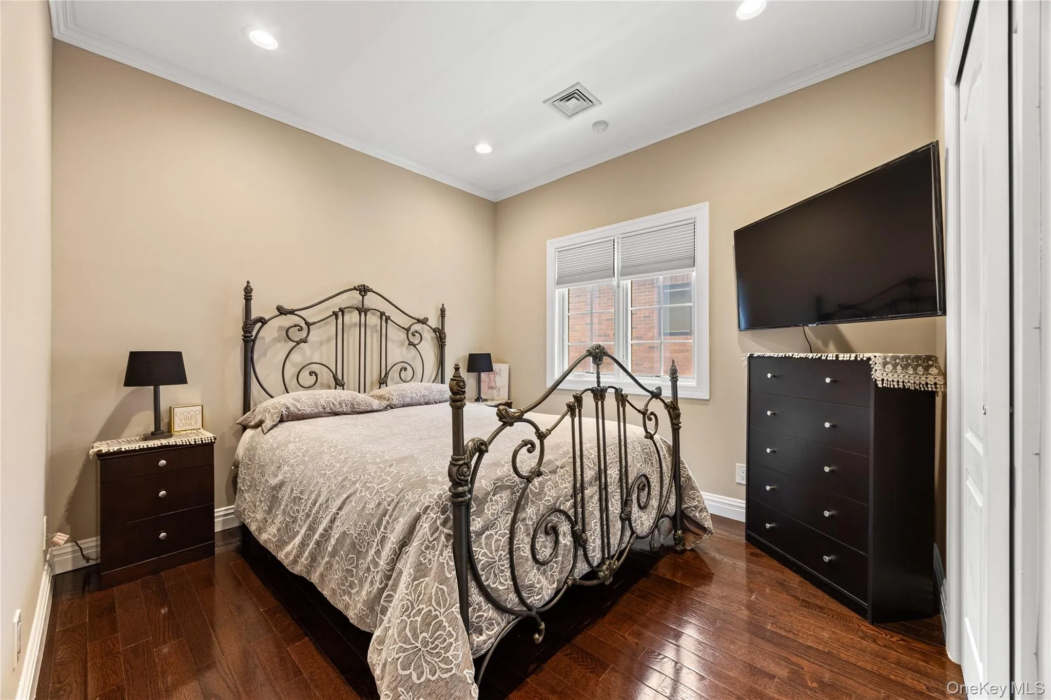 Bedroom featuring rich wood-finish flooring, recessed lighting, and a window with blinds Bedroom featuring rich wood-finish flooring, recessed lighting, and a window with blinds