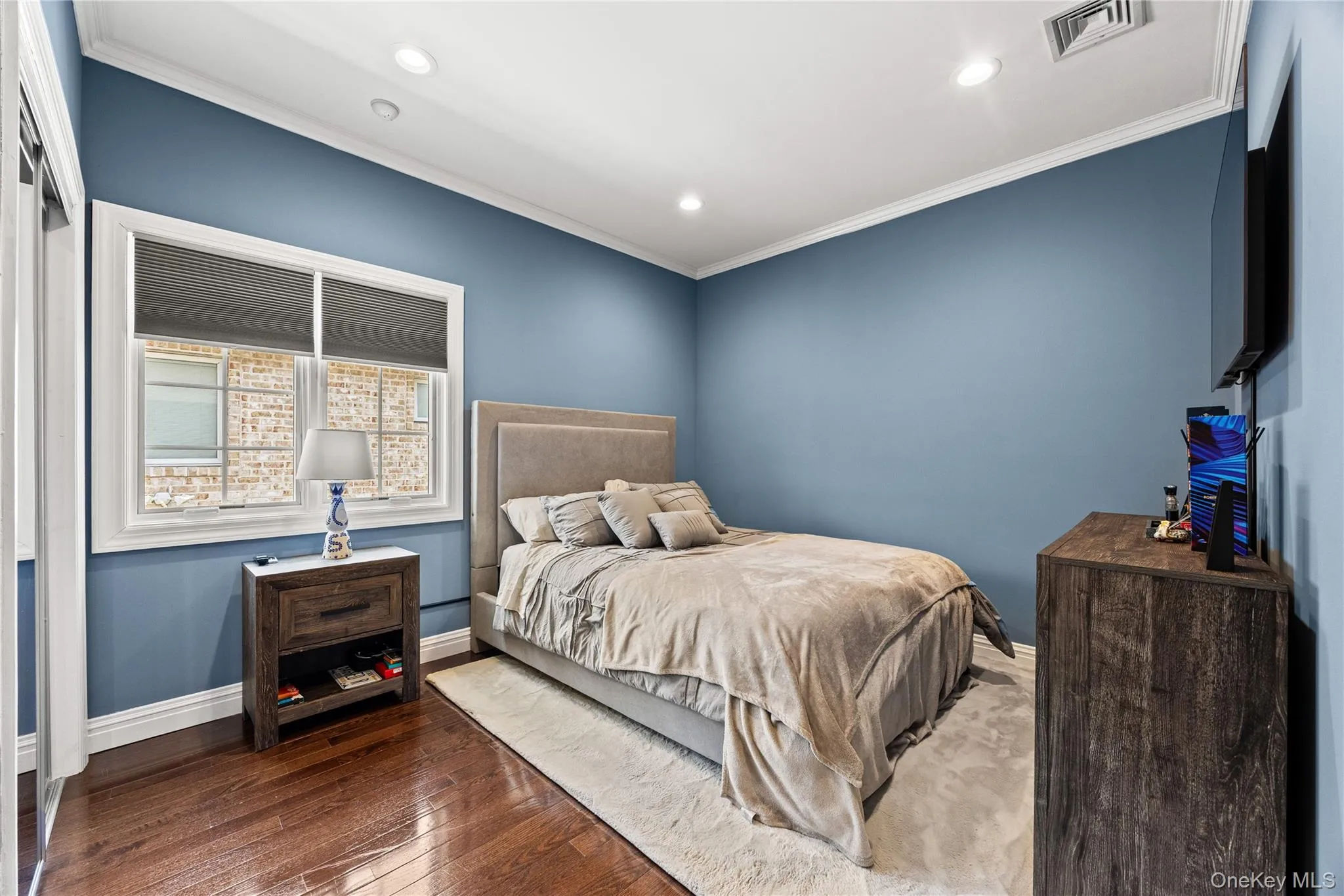 Interior room featuring blue painted walls, crown molding, and recessed lighting Interior room featuring blue painted walls, crown molding, and recessed lighting