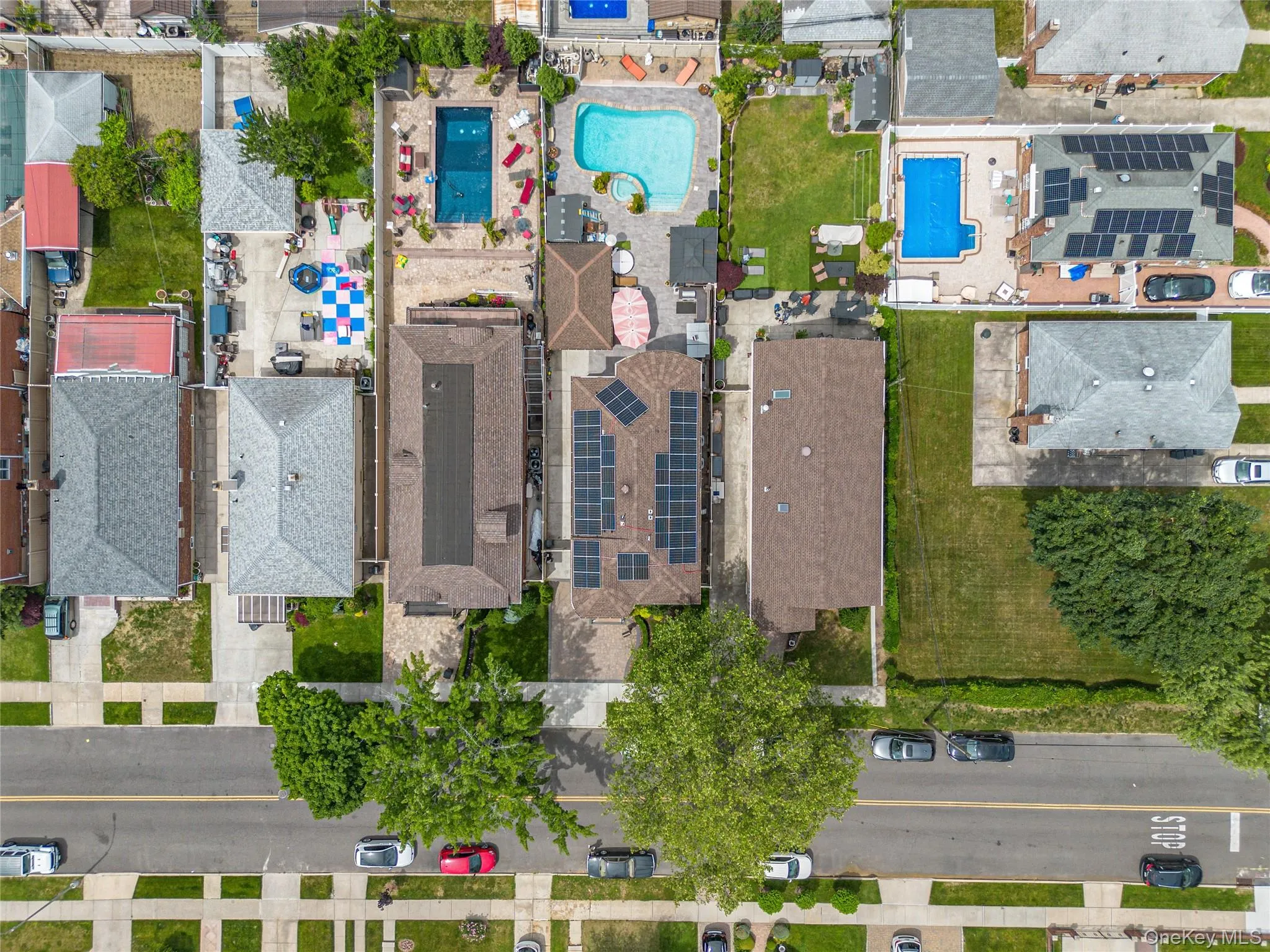 Aerial perspective showcasing residential properties with diverse backyard amenities Aerial perspective showcasing residential properties with diverse backyard amenities