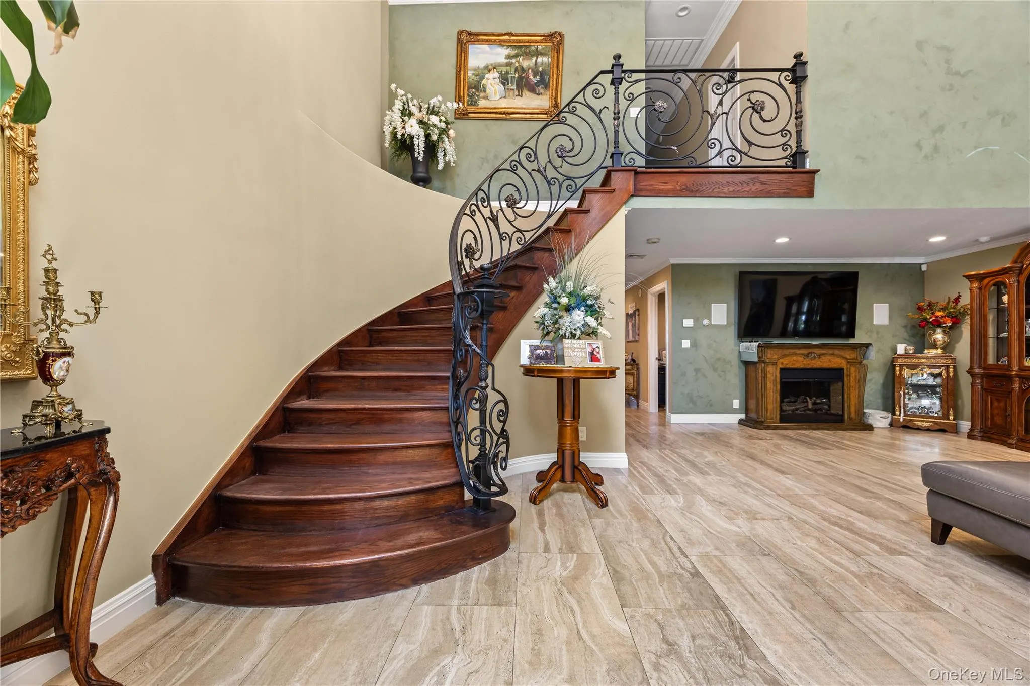 Curved wooden staircase with wrought iron balusters and a wood-finish handrail, set against two-tone walls Curved wooden staircase with wrought iron balusters and a wood-finish handrail, set against two-tone walls