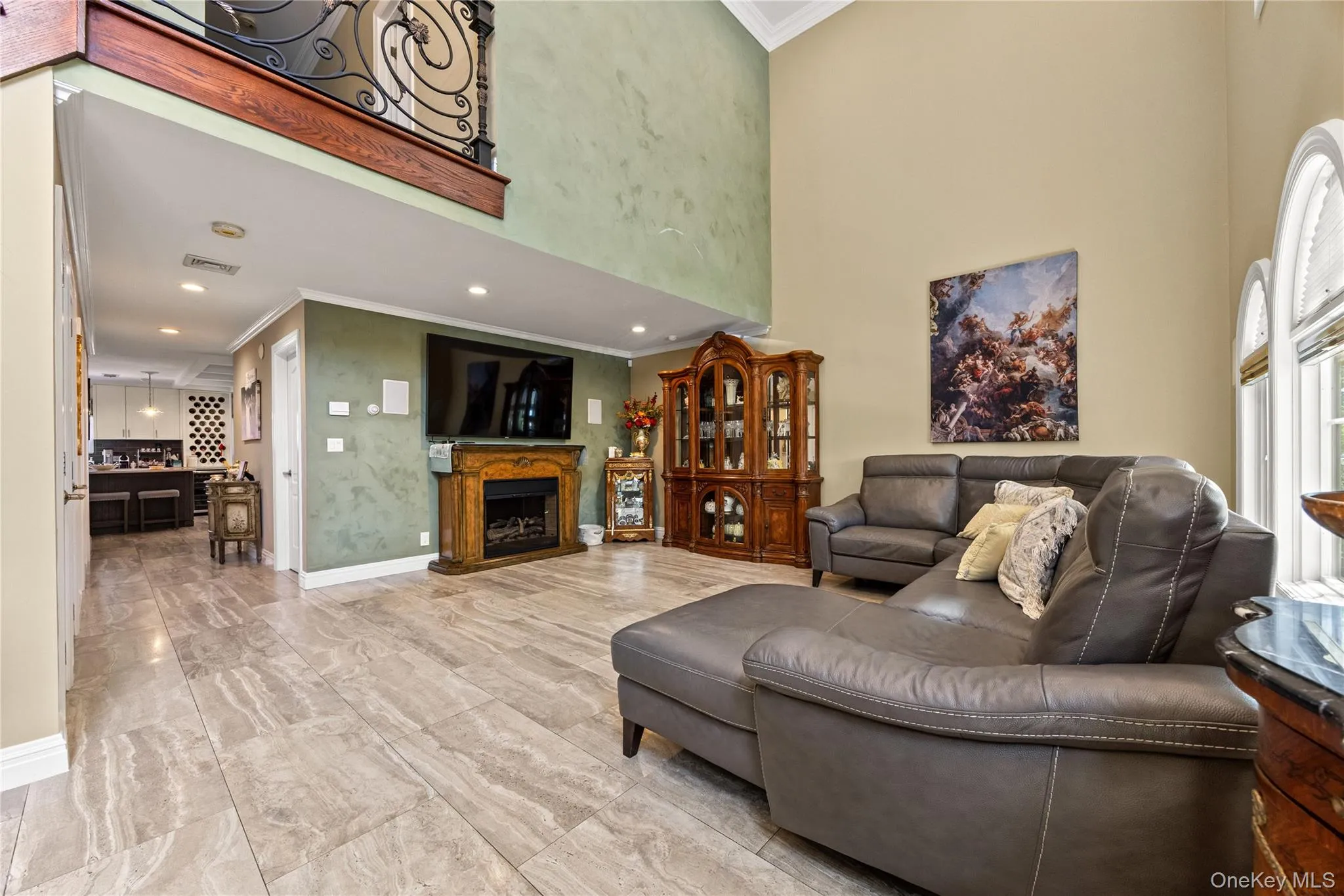 Living area featuring high ceilings, large arched windows, and tile flooring Living area featuring high ceilings, large arched windows, and tile flooring