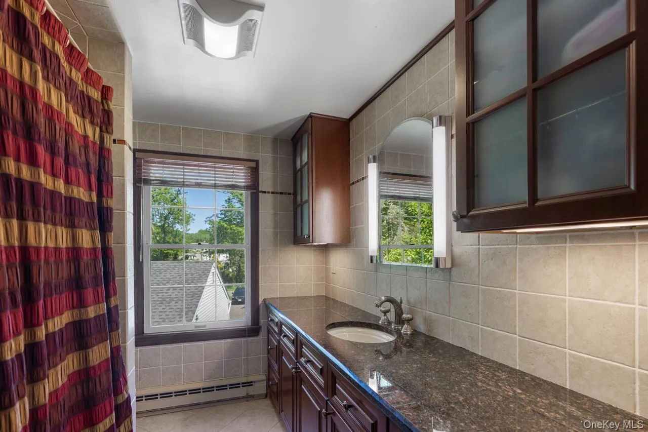 Second-floor full bathroom with dual vanity and granite countertops Second-floor full bathroom with dual vanity and granite countertops
