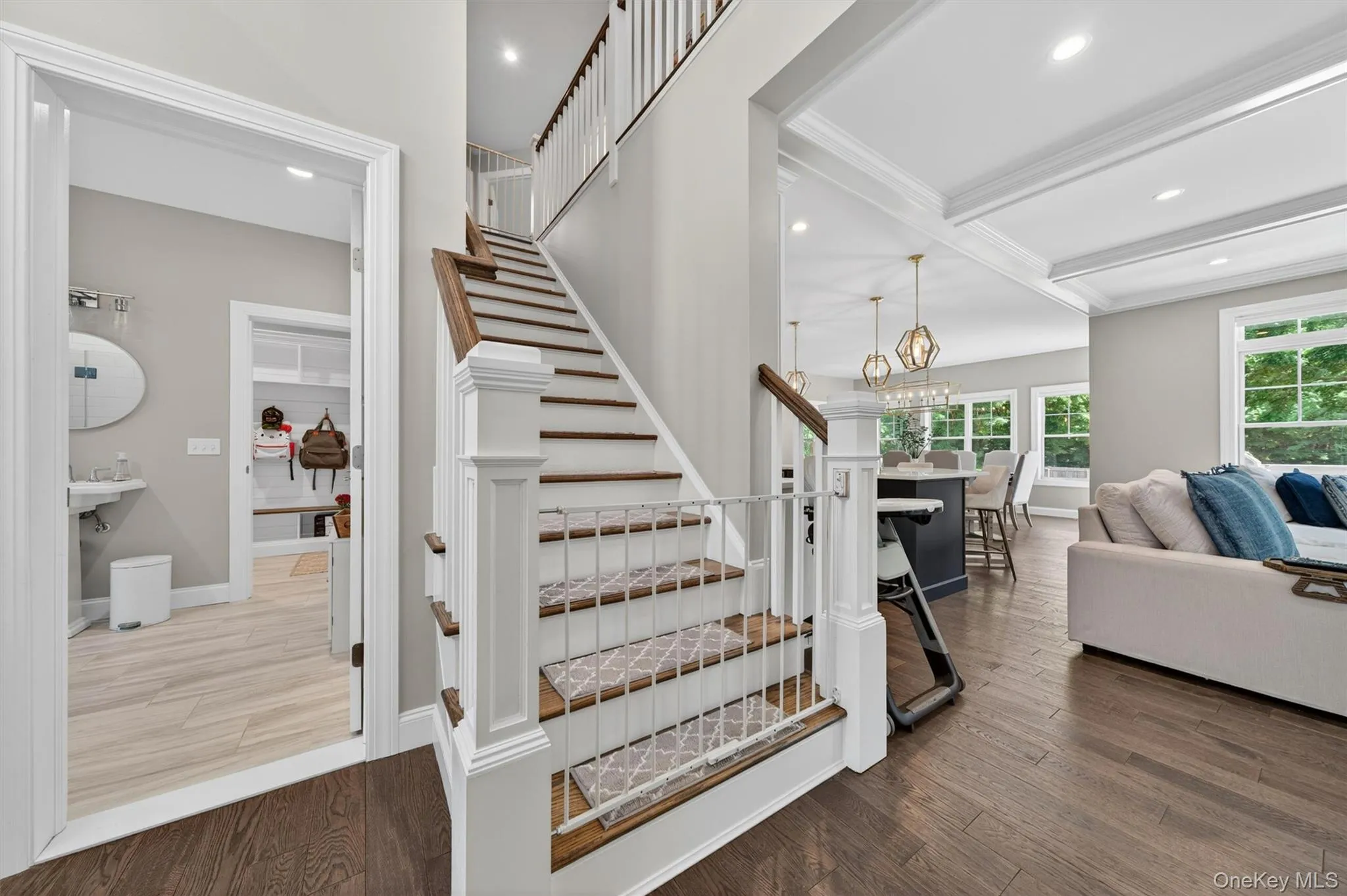 Hardwood flooring extends from the living area through to the staircase with wood treads and white risers Hardwood flooring extends from the living area through to the staircase with wood treads and white risers