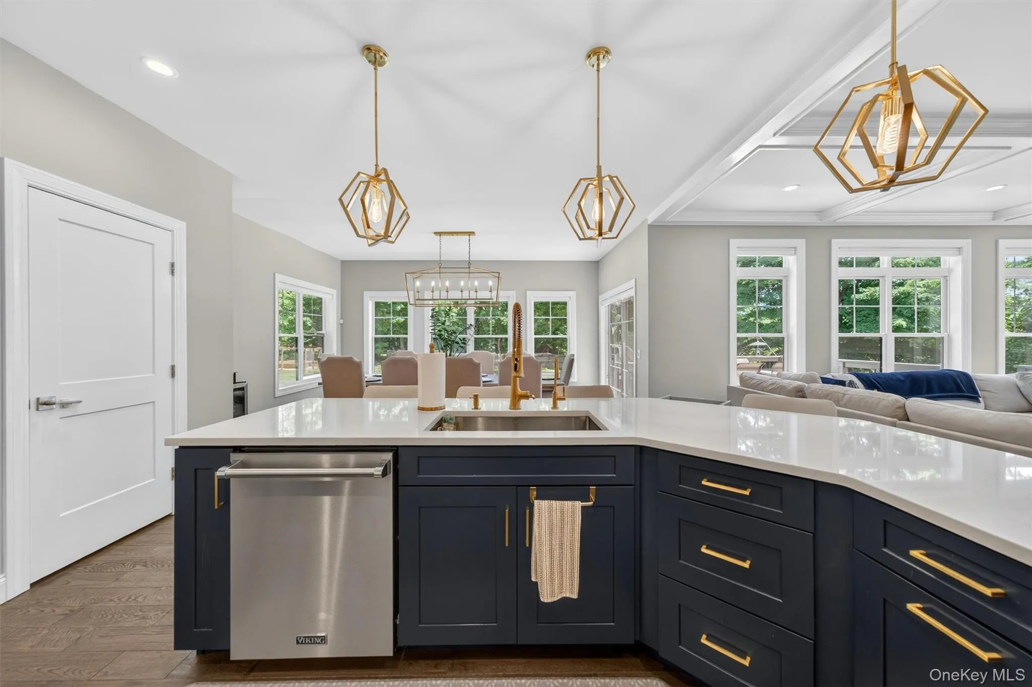 Kitchen island with a stainless steel dishwasher, a gold-toned faucet, and a white countertop Kitchen island with a stainless steel dishwasher, a gold-toned faucet, and a white countertop