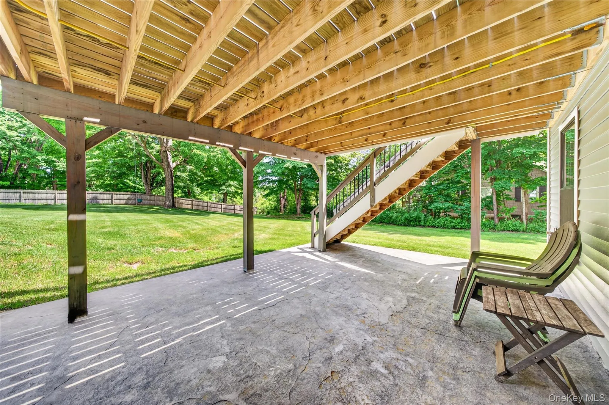 Covered patio area featuring a stamped concrete surface and wood support beams Covered patio area featuring a stamped concrete surface and wood support beams