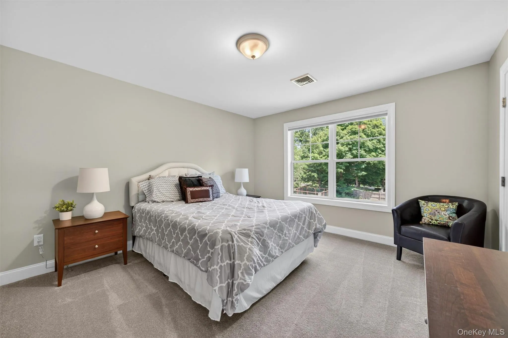Carpeted bedroom featuring neutral wall tones and a window with white trim Carpeted bedroom featuring neutral wall tones and a window with white trim