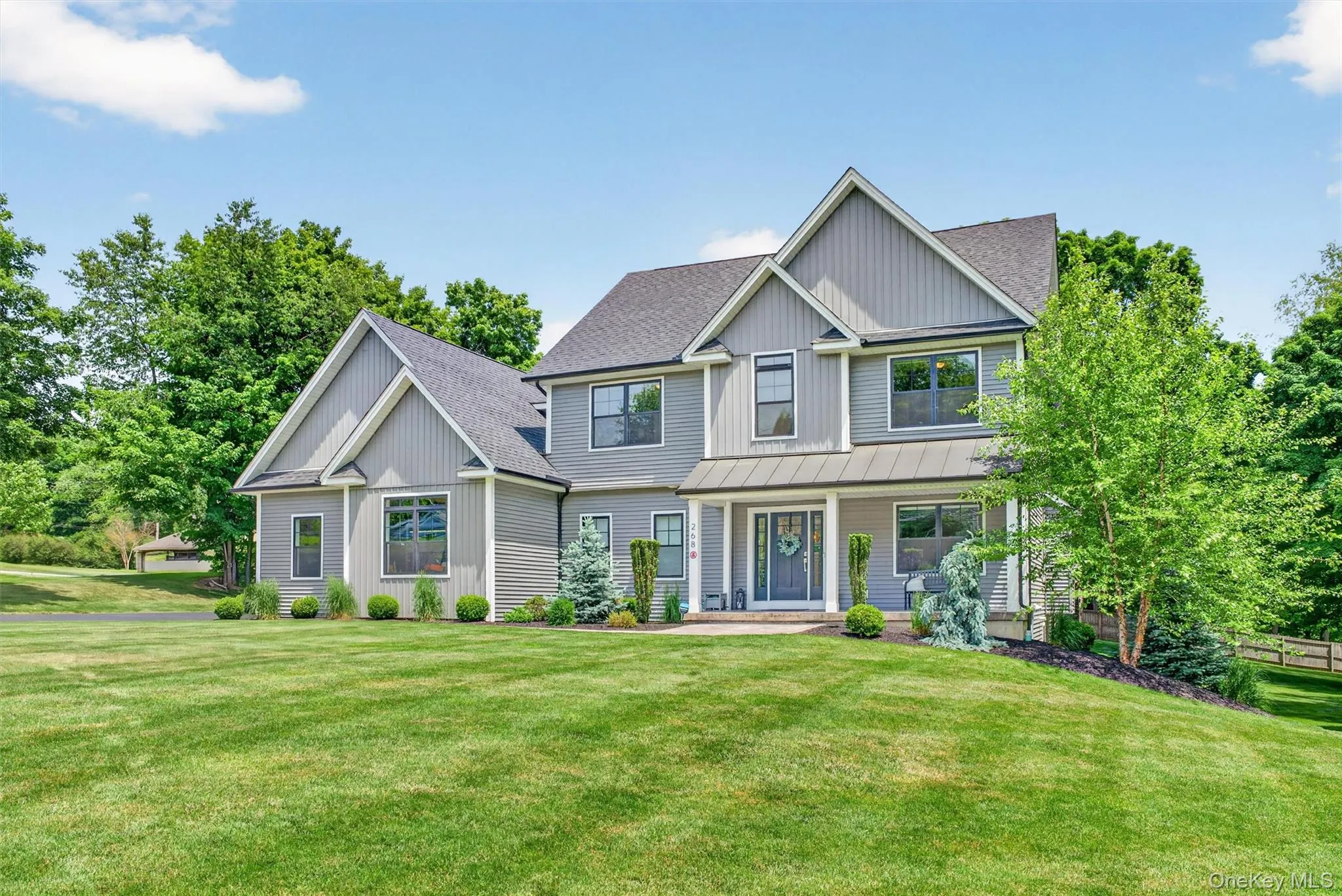 Contemporary colonial residence featuring a gabled roofline and light grey siding Contemporary colonial residence featuring a gabled roofline and light grey siding
