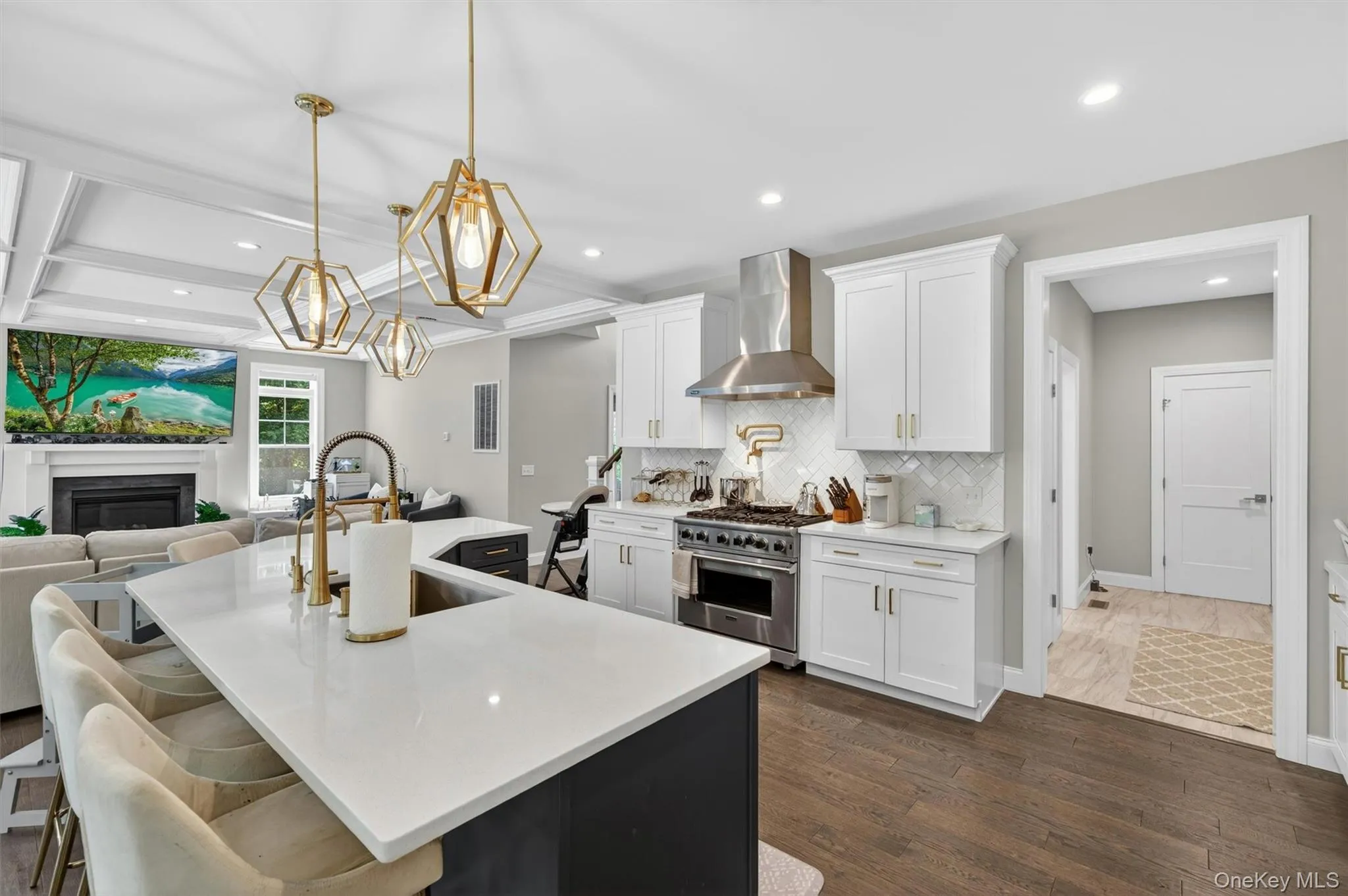 Kitchen island with a white countertop and seating, featuring a gold-finish faucet and undermount sink Kitchen island with a white countertop and seating, featuring a gold-finish faucet and undermount sink