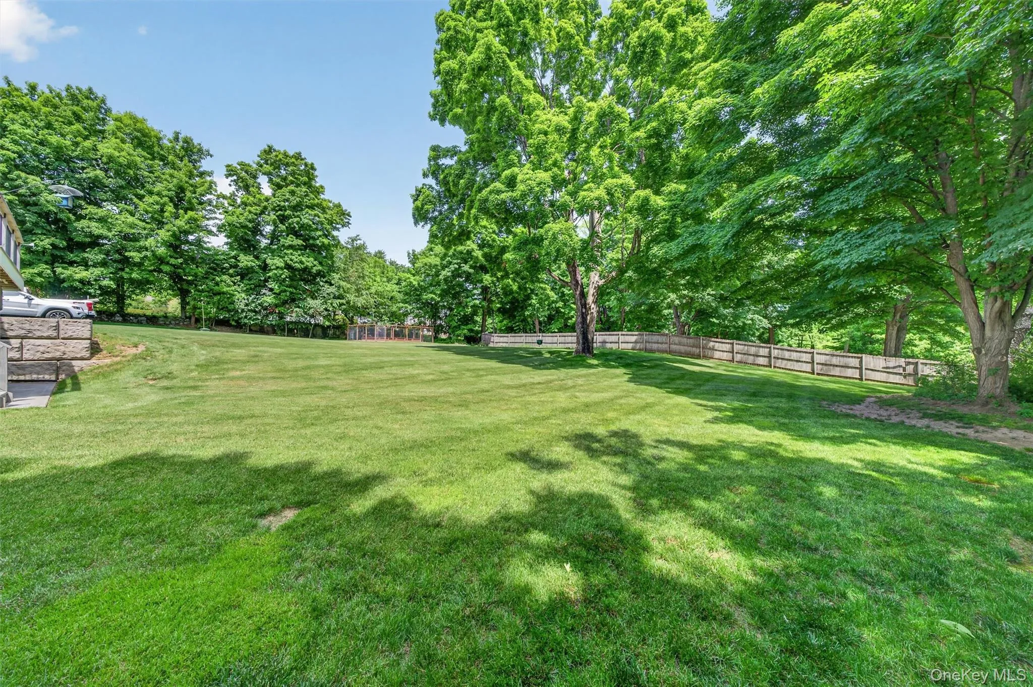 Expansive green lawn with a wood fence perimeter Expansive green lawn with a wood fence perimeter