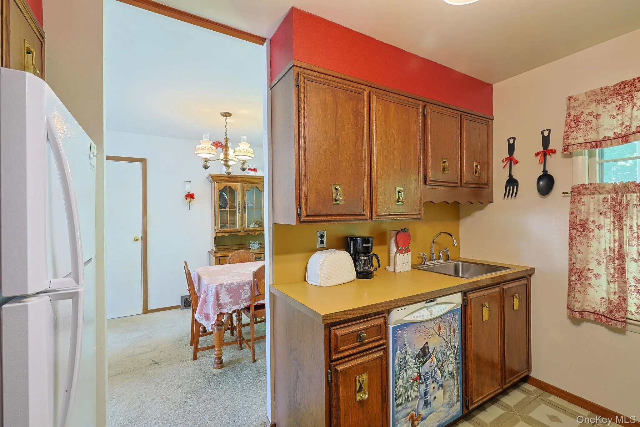 Kitchen area featuring wood cabinetry, a stainless steel sink, and countertops. Kitchen area featuring wood cabinetry, a stainless steel sink, and countertops.
