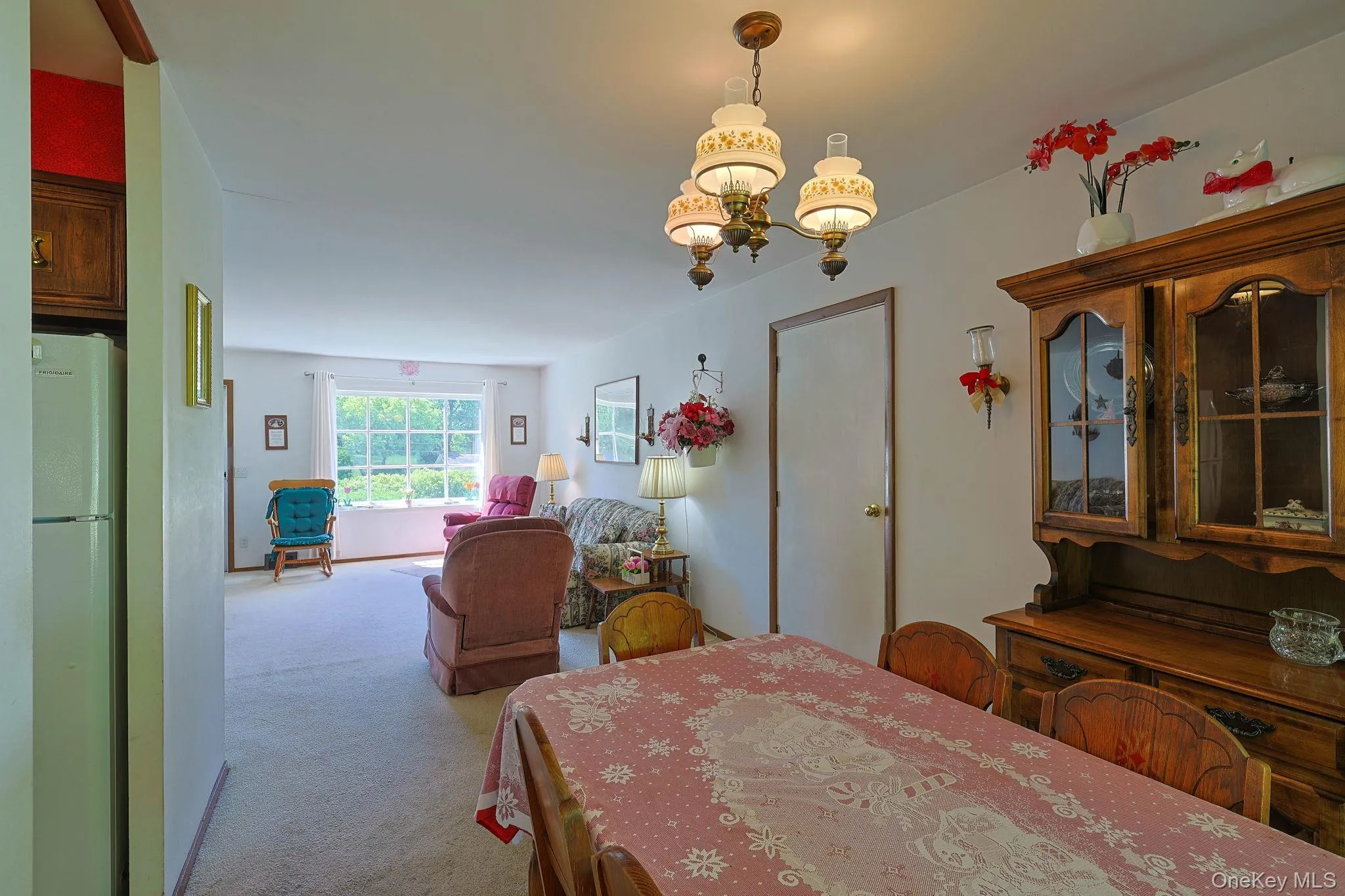 Dining area featuring a classic chandelier over the table. Dining area featuring a classic chandelier over the table.