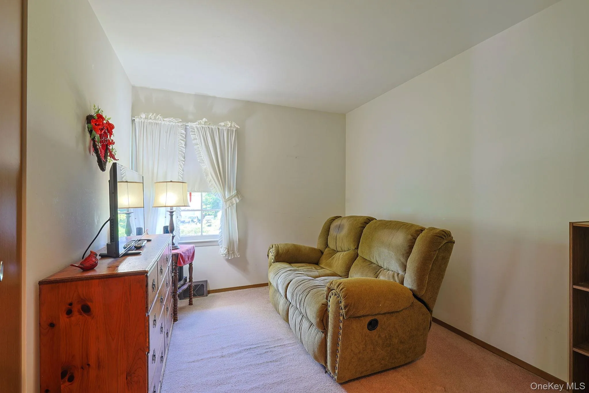Carpeted bedroom on the first floor is currently a comfortable place to watch television or read. Carpeted bedroom on the first floor is currently a comfortable place to watch television or read.
