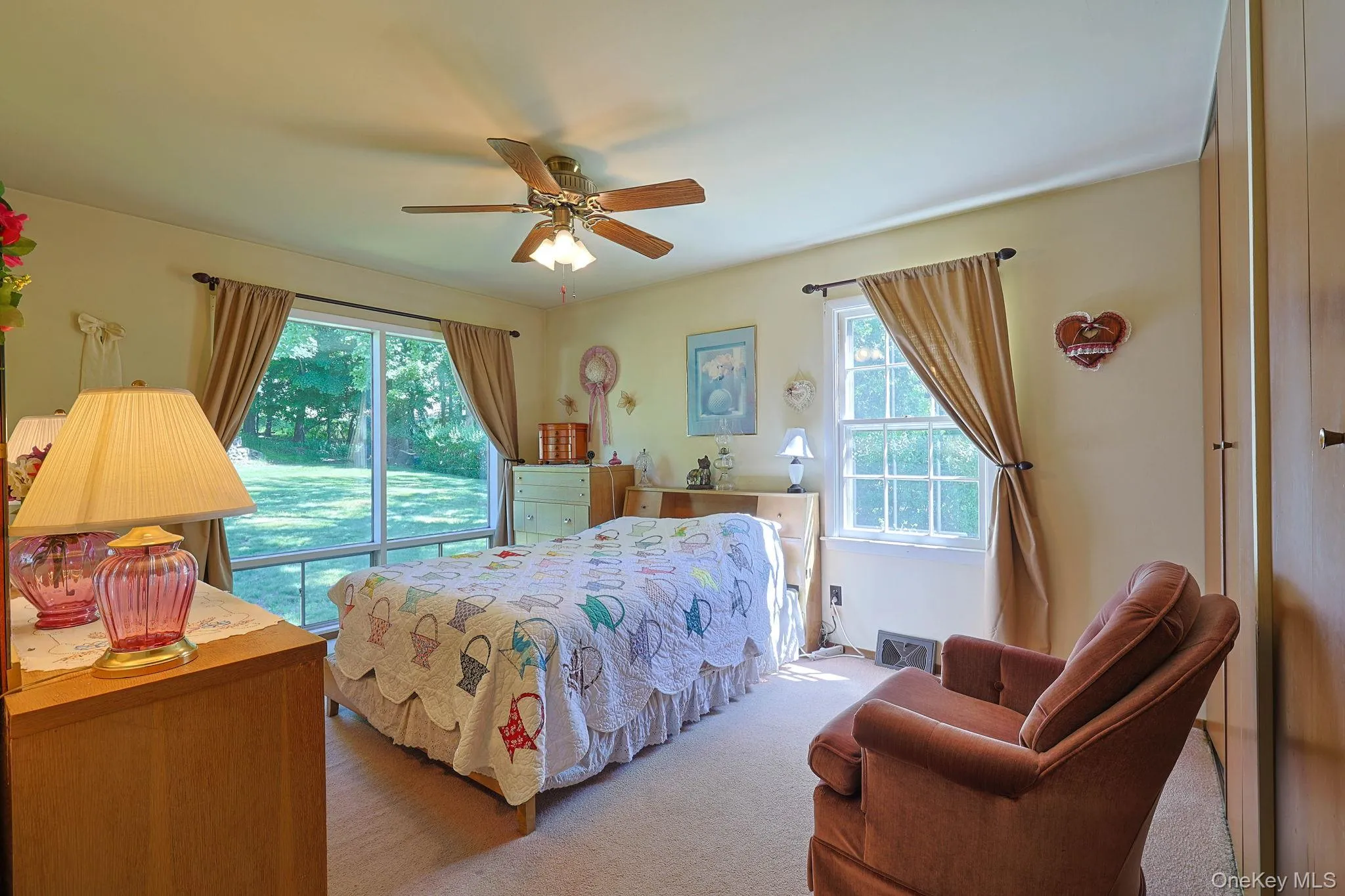 The primary bedroom features a ceiling fan with integrated lighting, a large picture window, and plenty of closet space. The primary bedroom features a ceiling fan with integrated lighting, a large picture window, and plenty of closet space.