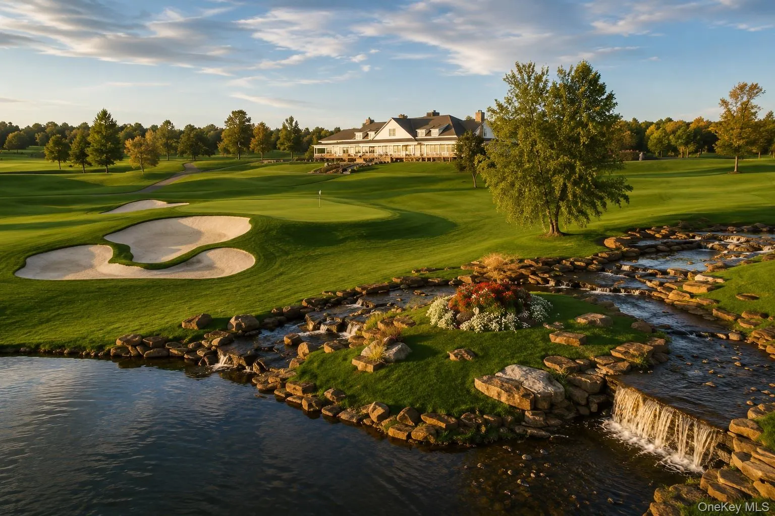 Expansive golf course landscape featuring a prominent clubhouse, manicured greens, sand traps, a flowing stream with rock features, and a tranquil pond Expansive golf course landscape featuring a prominent clubhouse, manicured greens, sand traps, a flowing stream with rock features, and a tranquil pond