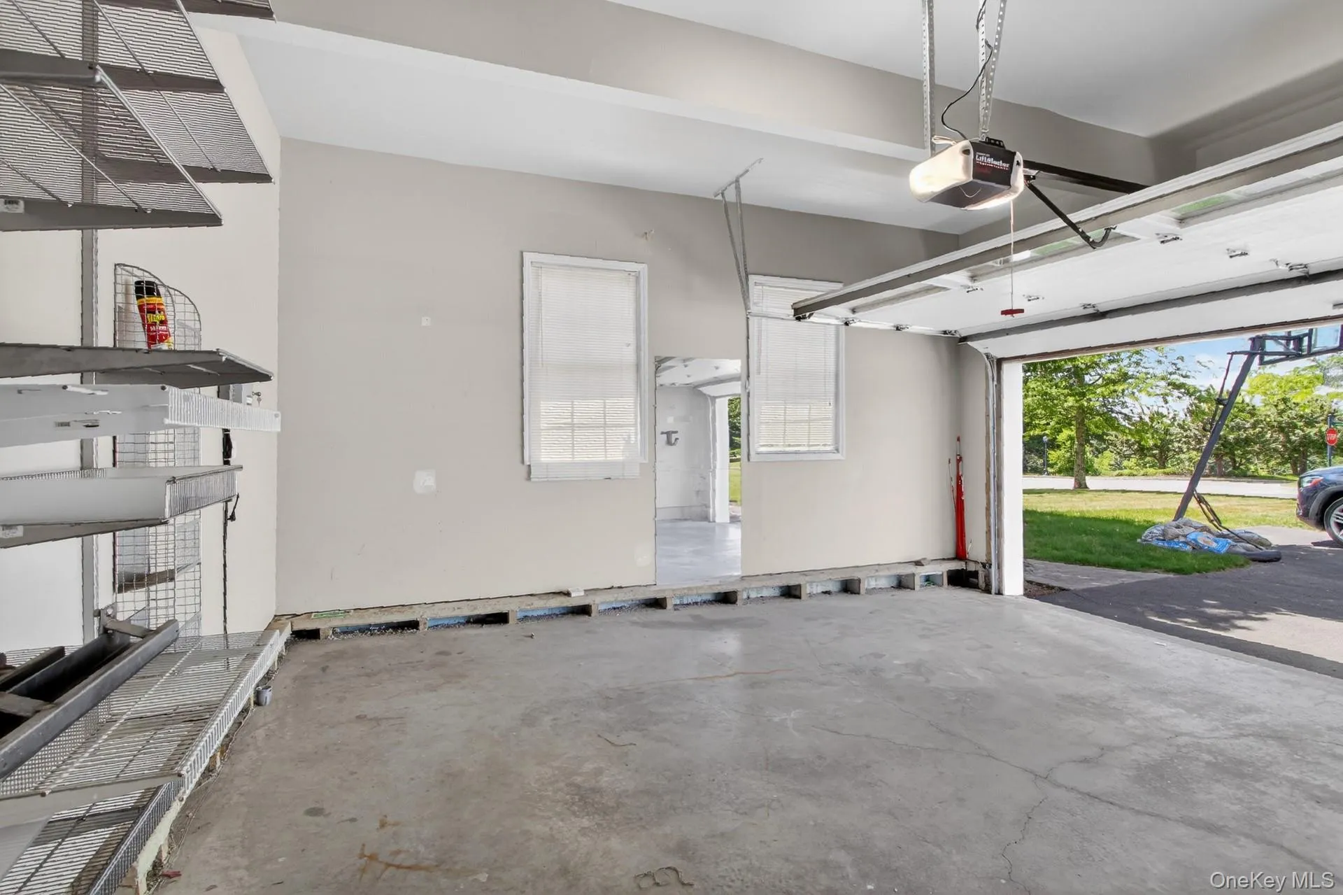 Attached garage space featuring a concrete floor, overhead door, and built-in shelving Attached garage space featuring a concrete floor, overhead door, and built-in shelving