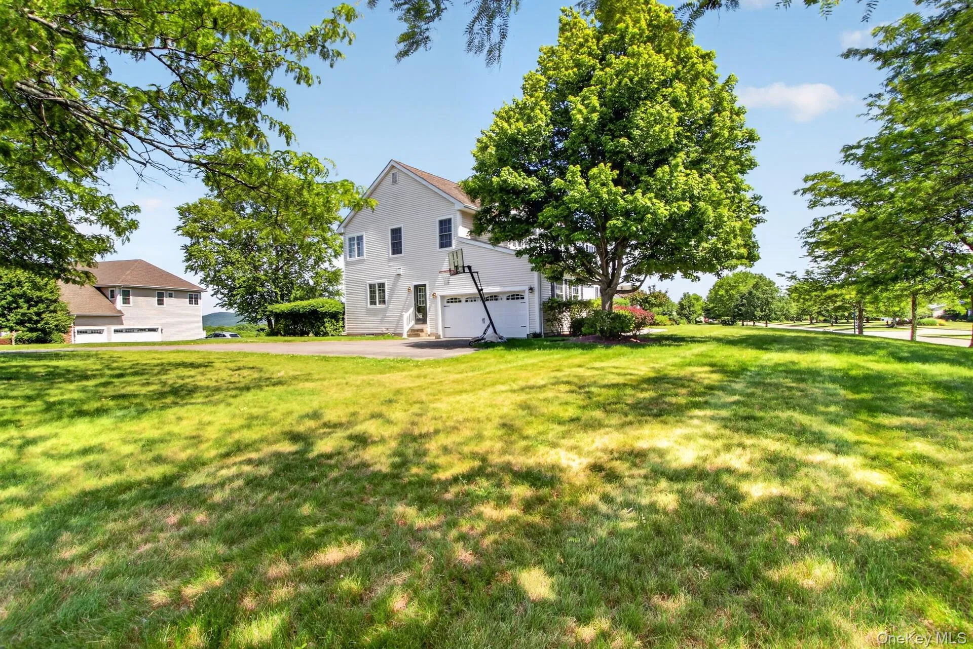 Expansive green lawn with mature trees providing partial shade Expansive green lawn with mature trees providing partial shade