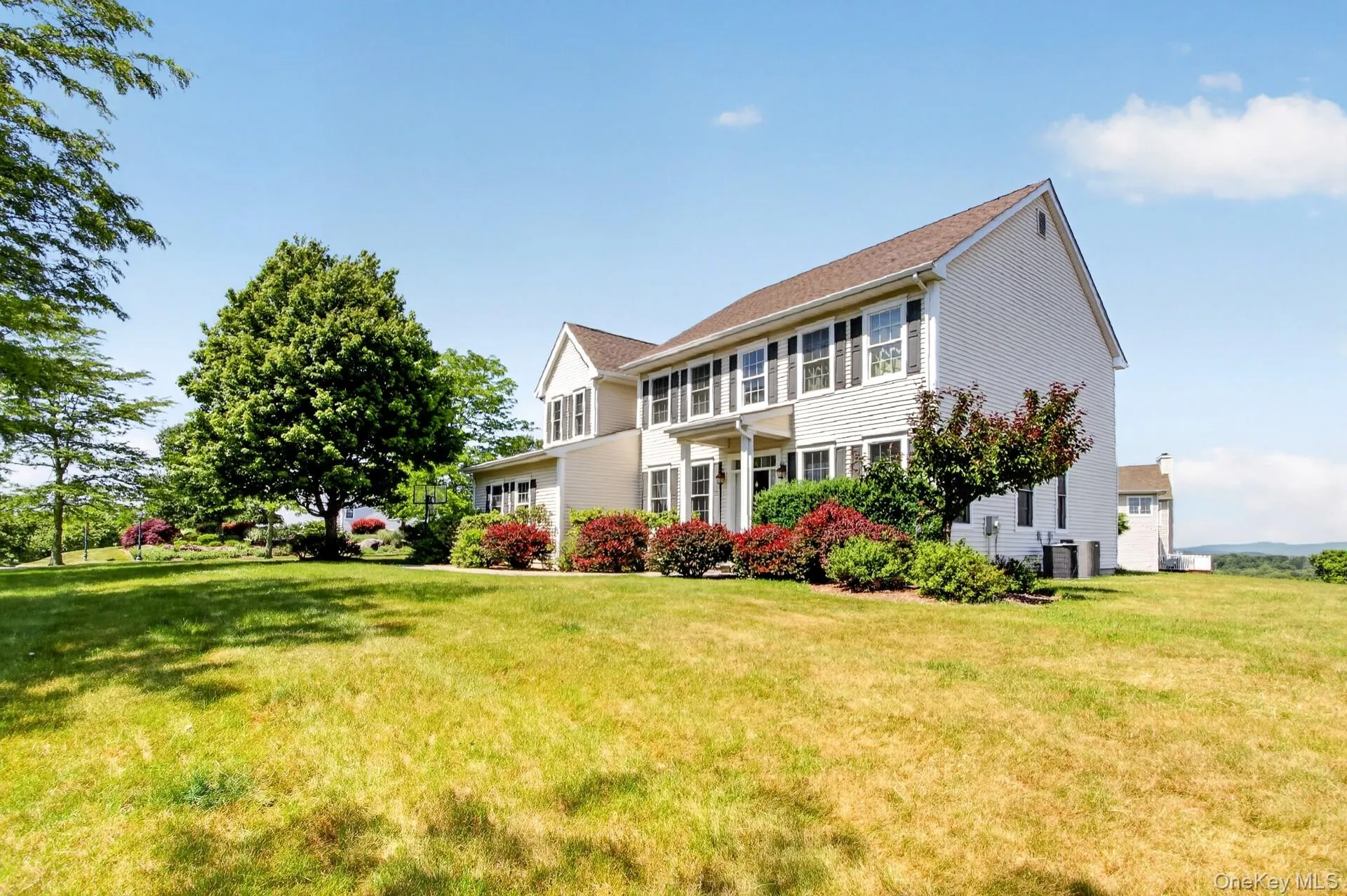Two-story residence with light-colored siding and dark shutters Two-story residence with light-colored siding and dark shutters