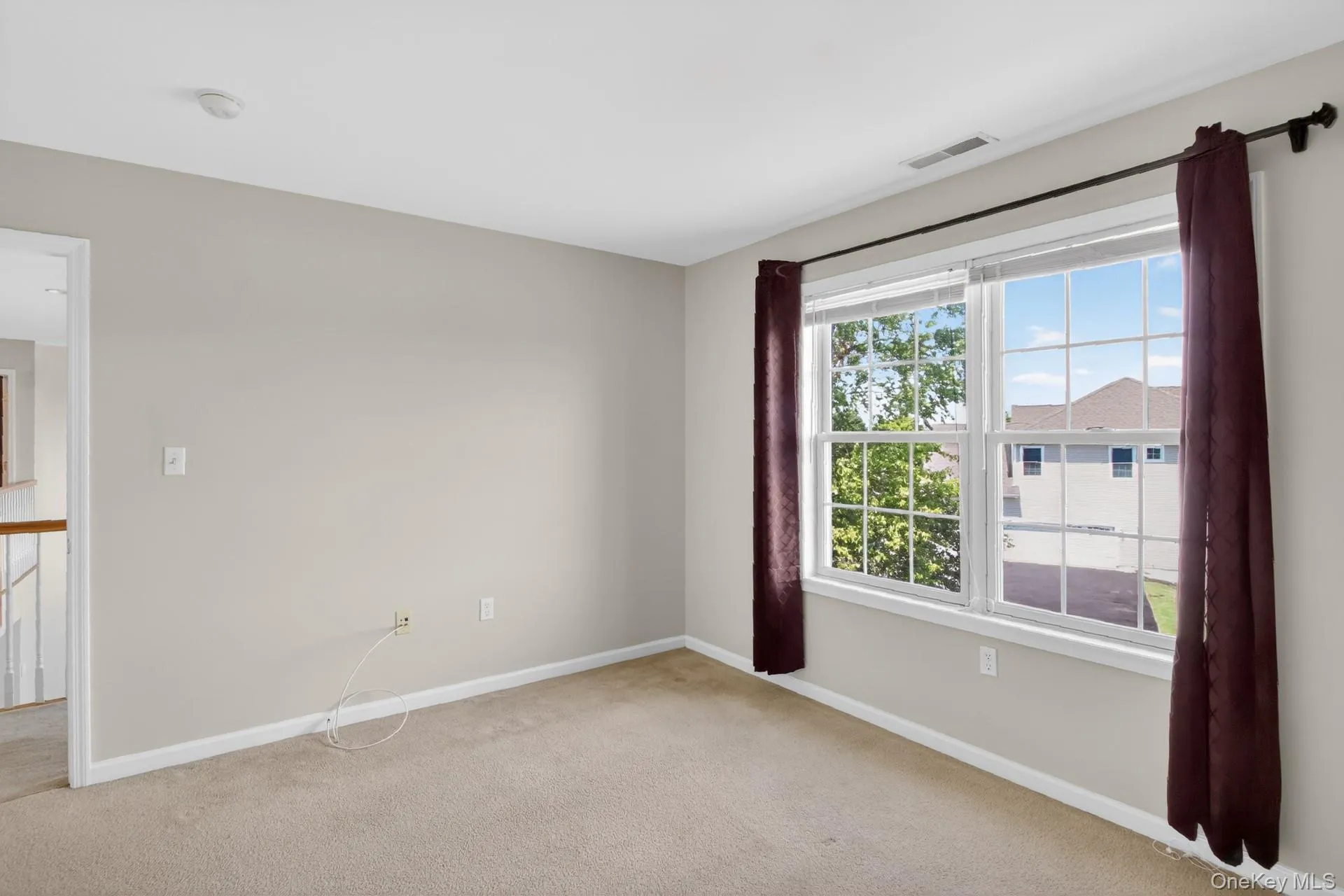 Room featuring neutral-toned carpeting and walls Room featuring neutral-toned carpeting and walls