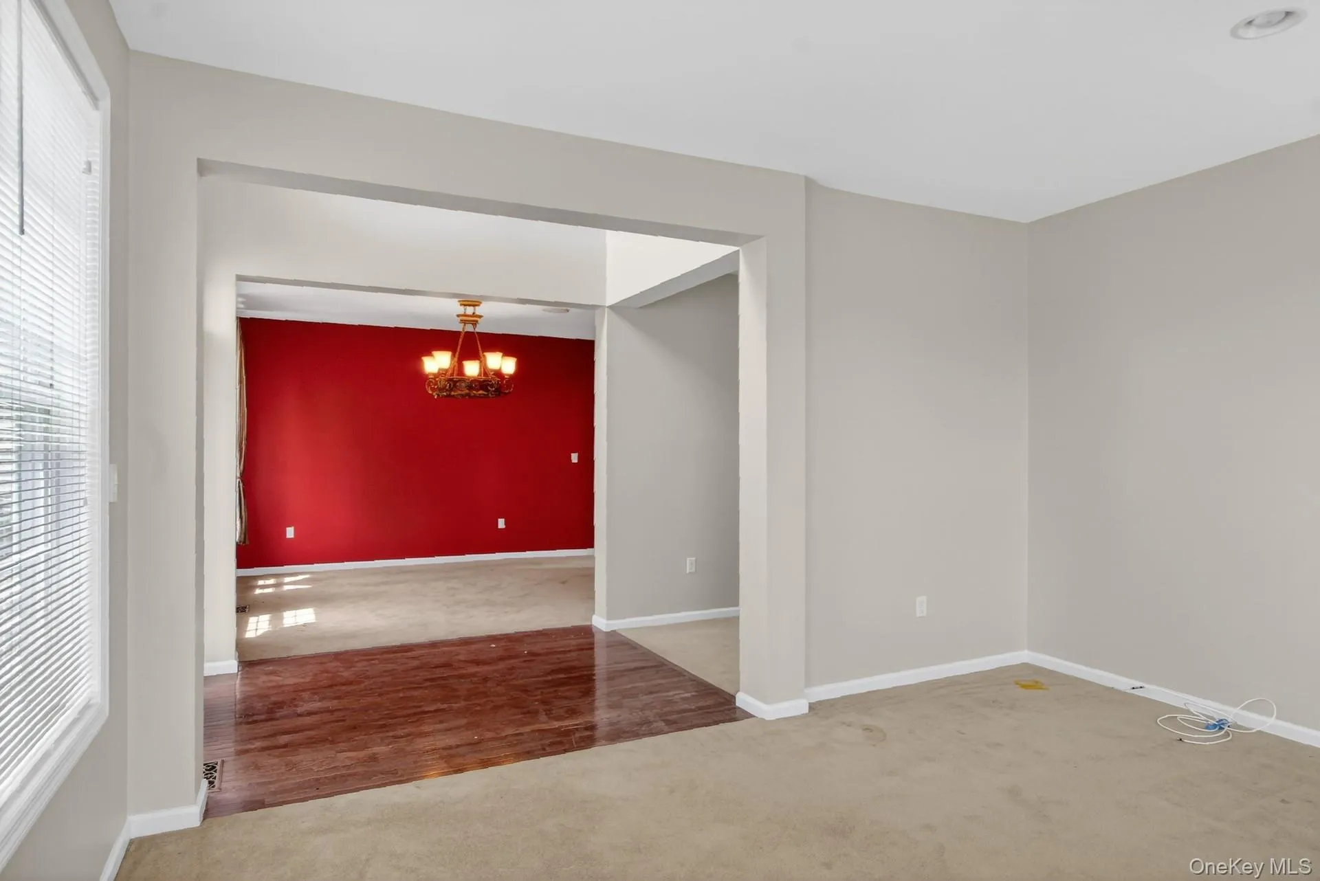 Archway leading to a room with red accent walls and a chandelier Archway leading to a room with red accent walls and a chandelier