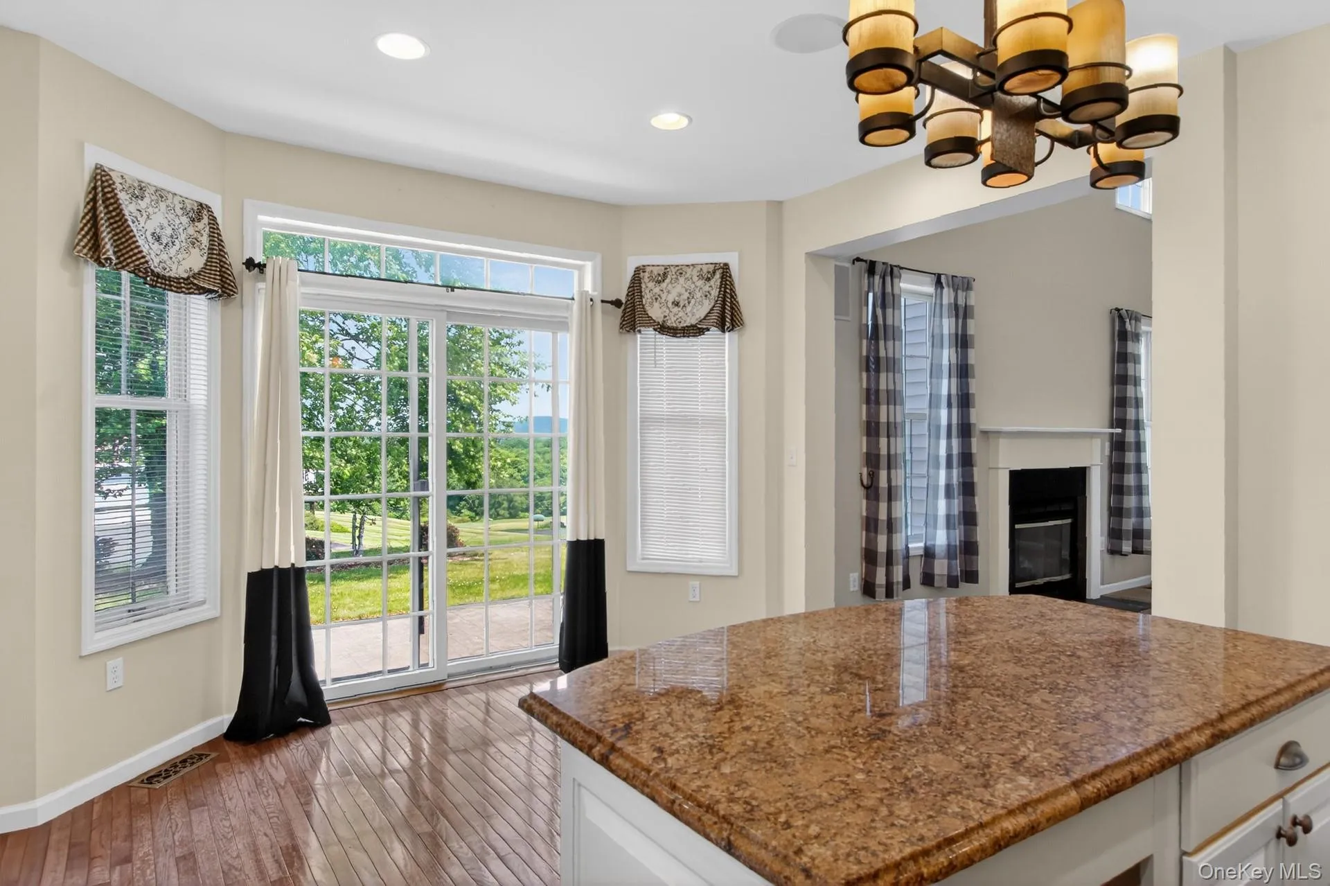Kitchen island featuring a polished granite countertop and white cabinetry with drawer pulls Kitchen island featuring a polished granite countertop and white cabinetry with drawer pulls