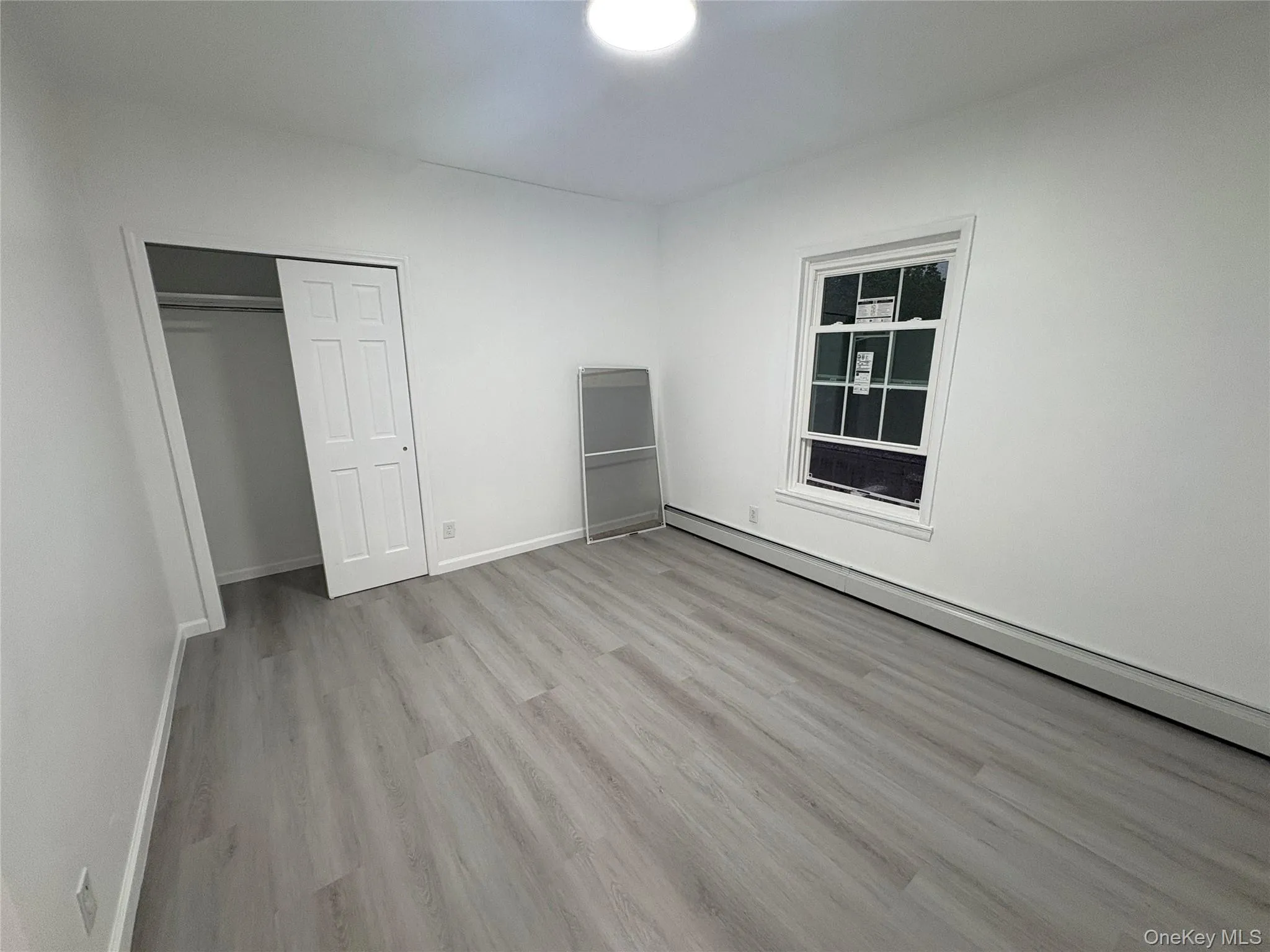 Second bedroom featuring updated flooring, fresh finishes, and generous closet space. Second bedroom featuring updated flooring, fresh finishes, and generous closet space.